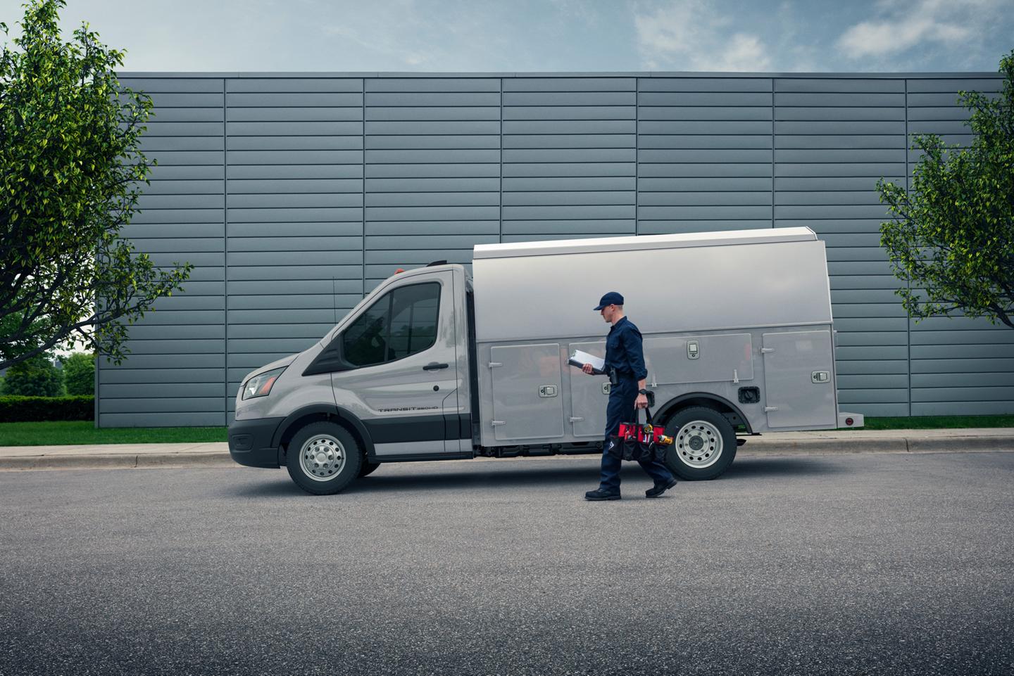 Worker walking up to a 2026 Transit® Chassis Cab parked on a street