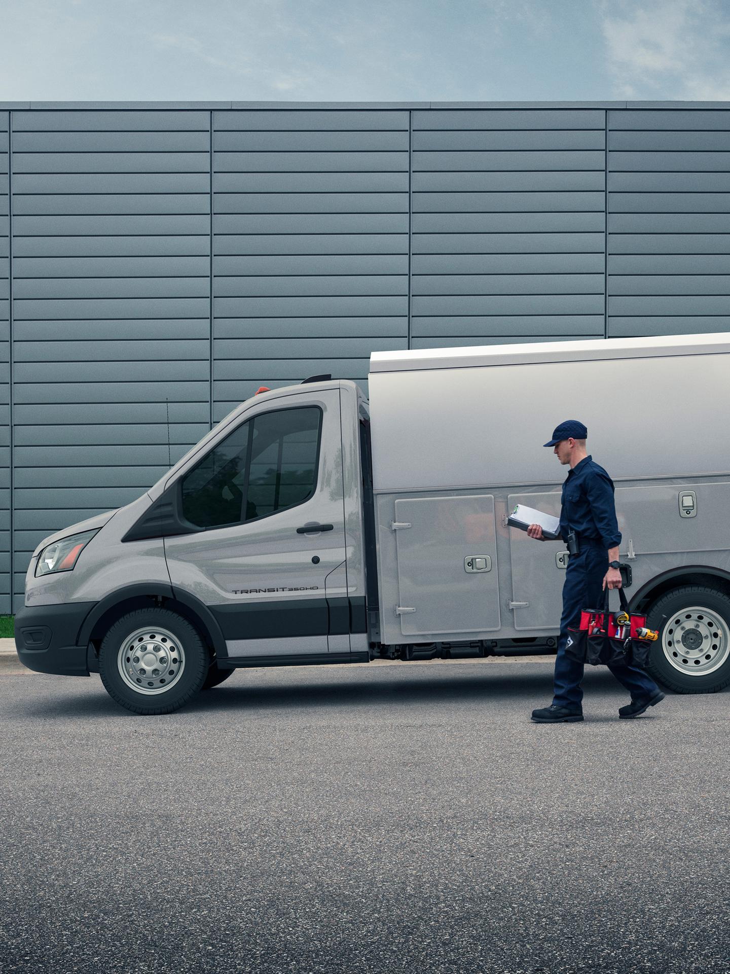 Worker walking up to a 2026 Transit® Chassis Cab parked on a street