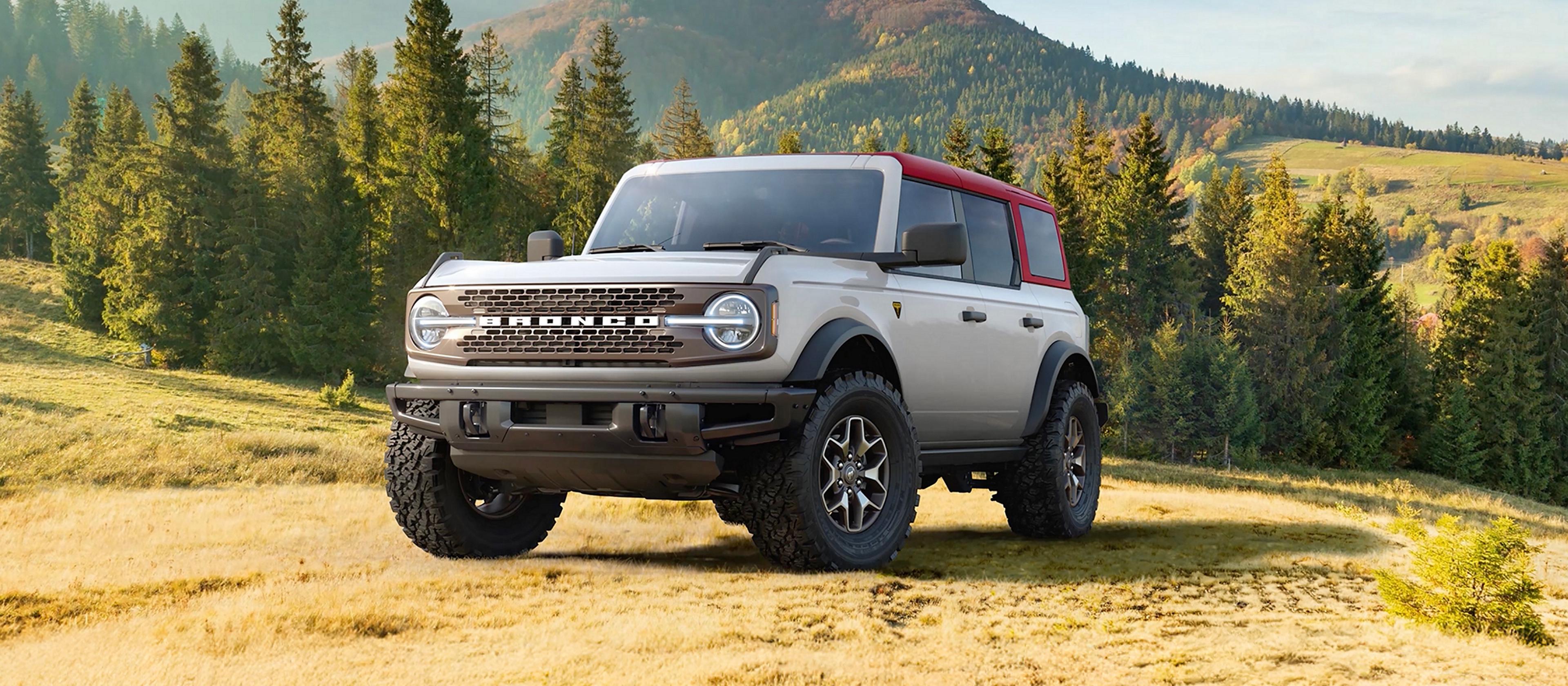 A 2026 Ford Bronco® SUV parked on a grassy hillside in the mountains