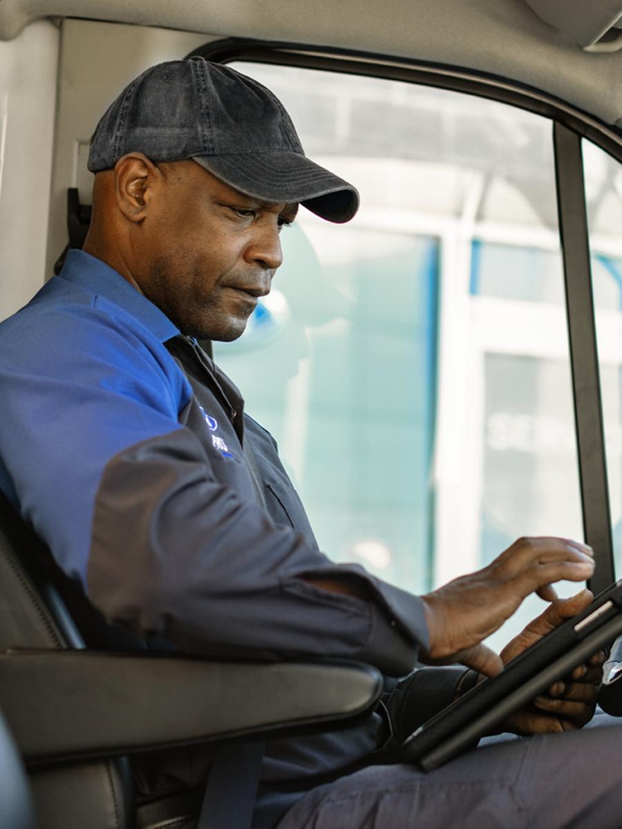 Ford technician sits in a vehicle.