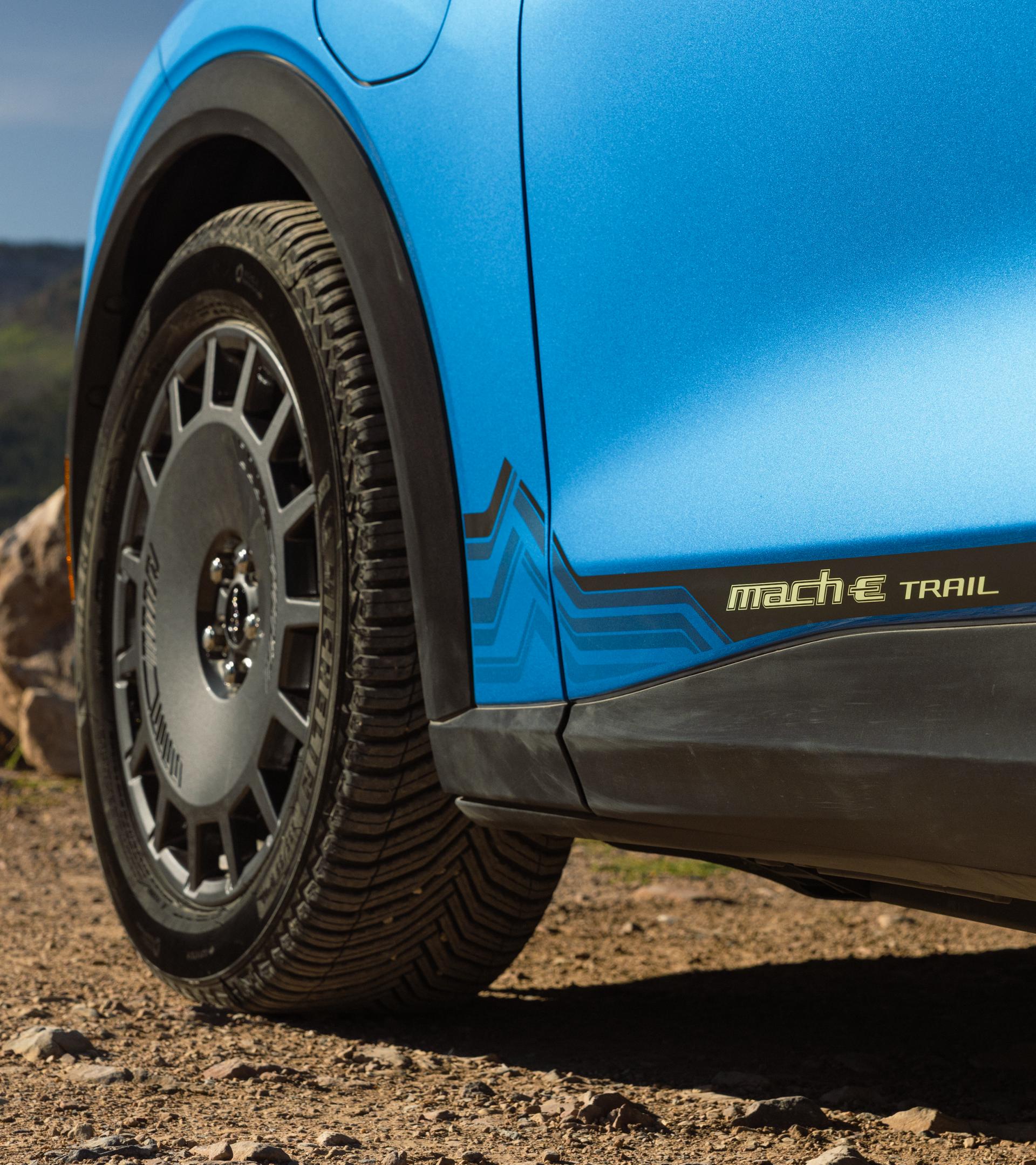 Close up of the 19” high-gloss Dark Carbonized Gray wheels and Michelin CrossClimate2 all-season performance tires on the 2027 Mustang Mach-E® SUV with optional Trail package