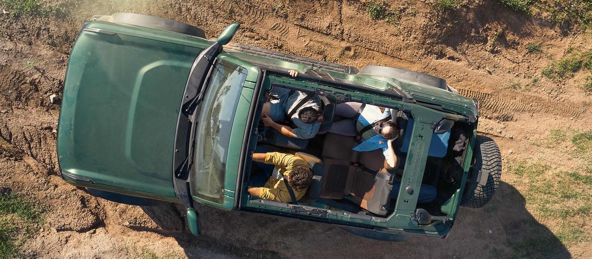 An overhead view of three people seated in a 2025 Ford Bronco® SUV with the roof removed