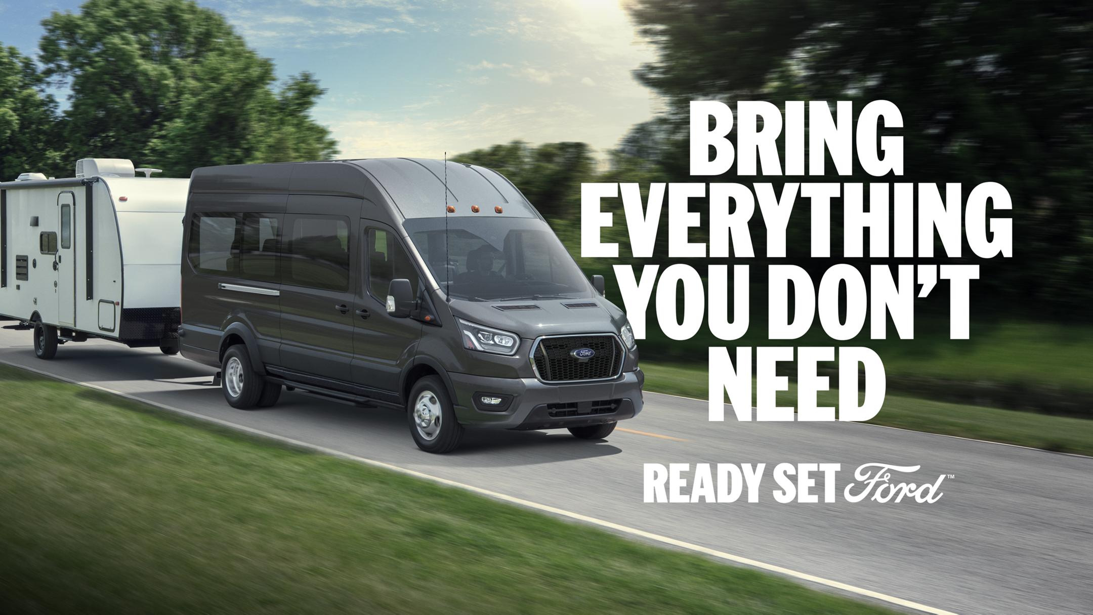 Three-quarter view of a 2025 Ford Transit towing an RV down a scenic road. White text “Bring Everything You Don’t Need” appears to the right of the Transit. In the lower right-hand corner appears white text “Ready Set Ford.”