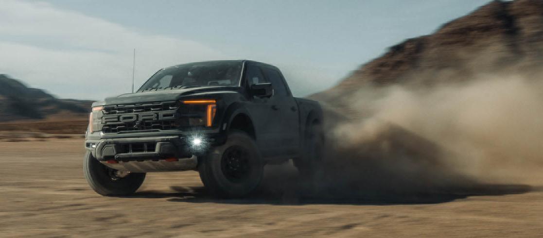 2026 Ford F-150® Raptor® R™ truck being driven in the desert kicking up cloud of sand