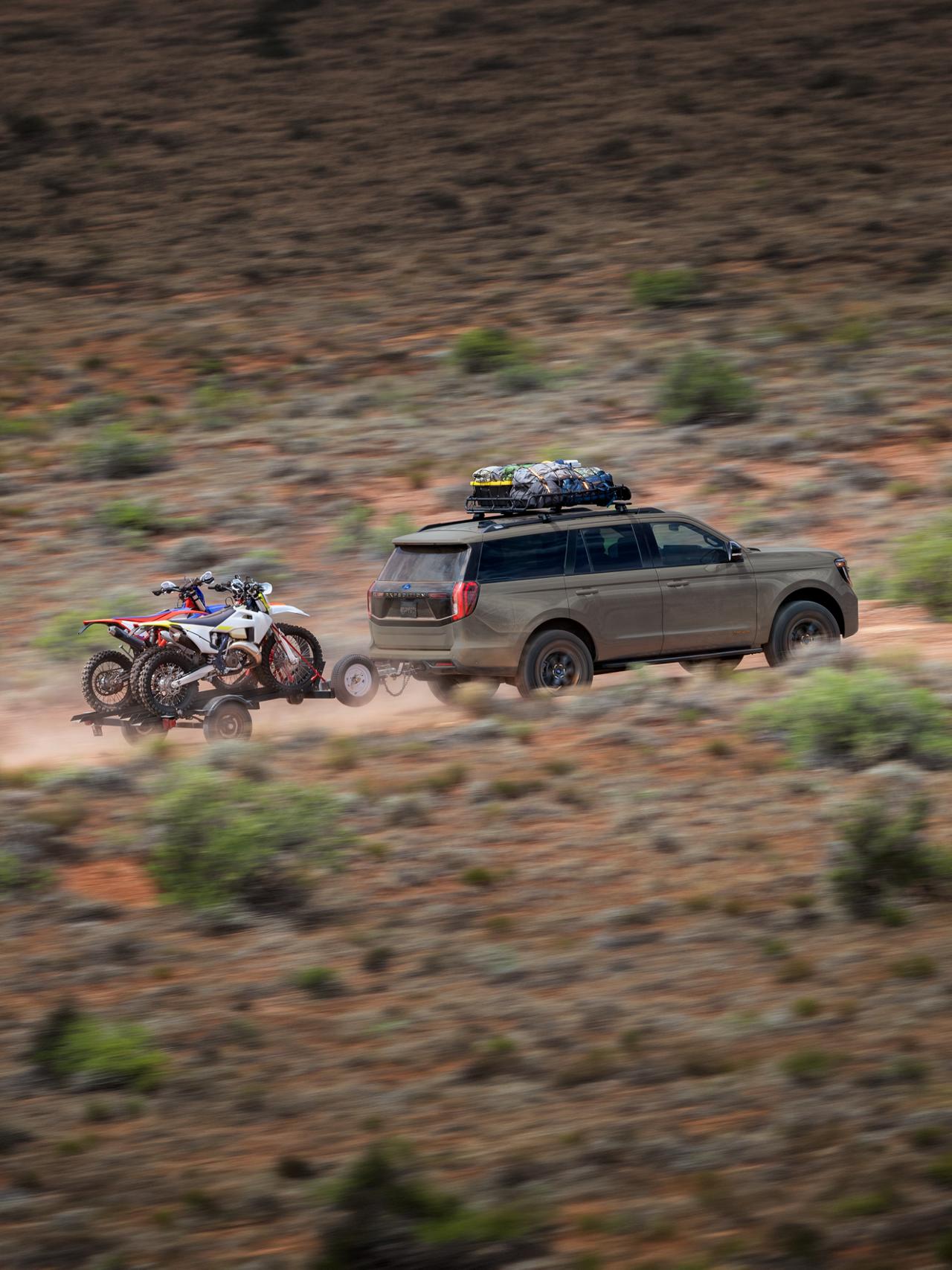2027 Ford Expedition® Tremor® SUV towing a dirt bike trailer in the desert