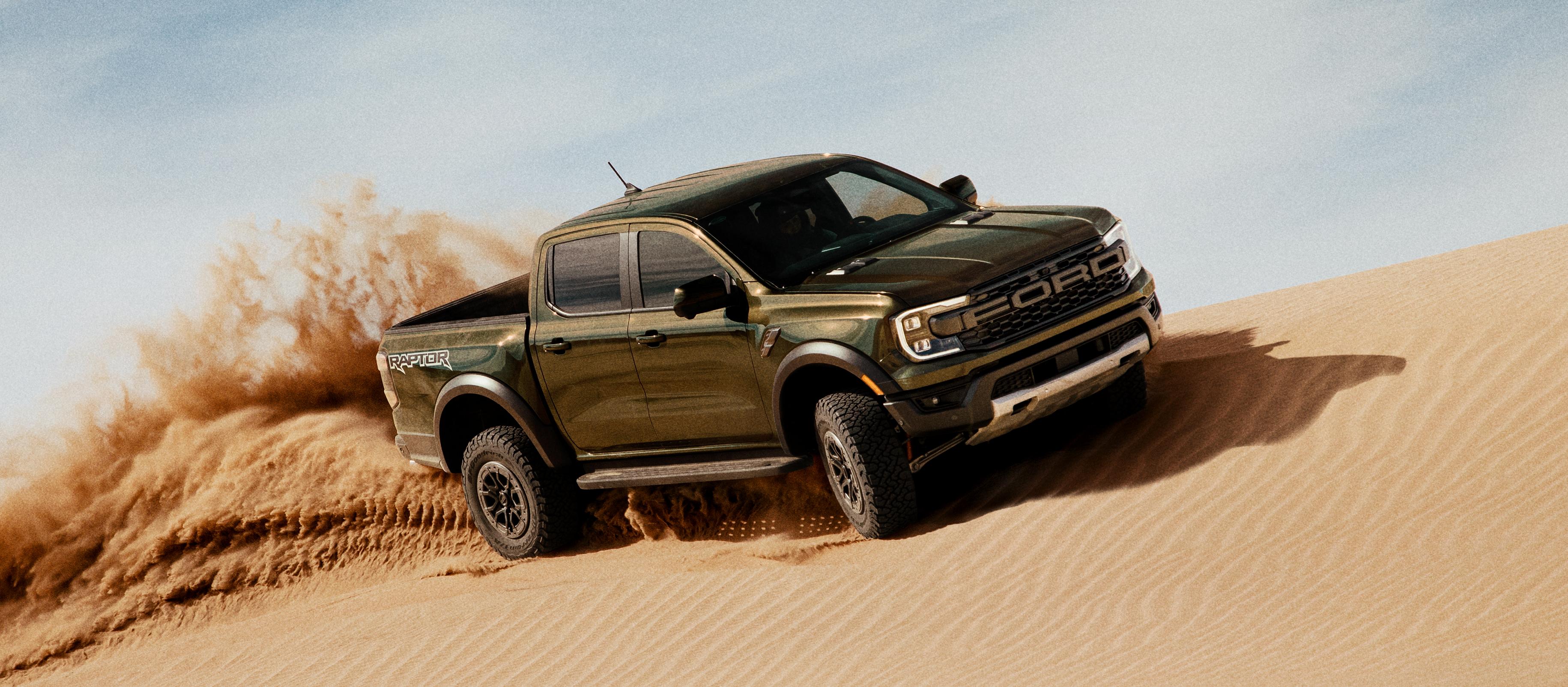 2026 Ford Ranger® Raptor® truck kicking up sand while being driven on a sand dune