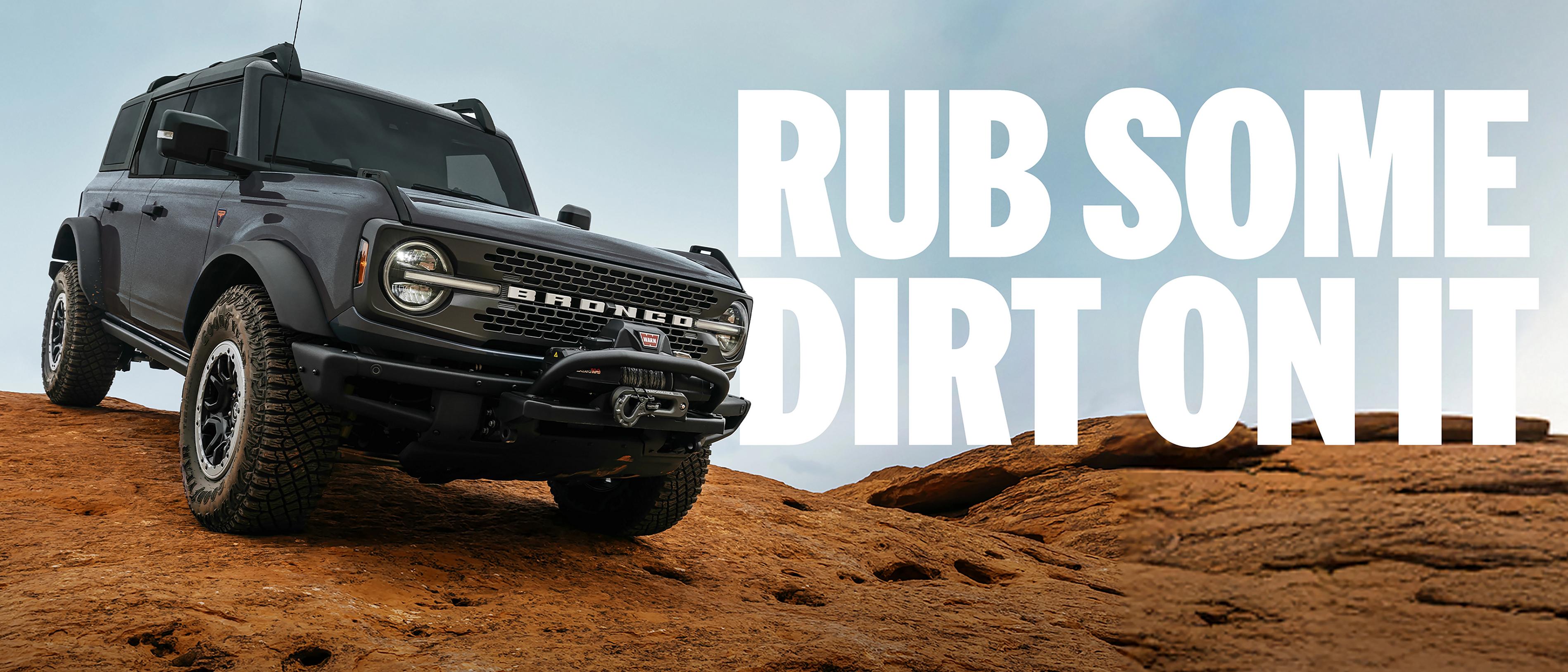 A 2026 Ford Bronco® SUV being driven down a dirt hillside. Caption: “Rub some dirt on it.”