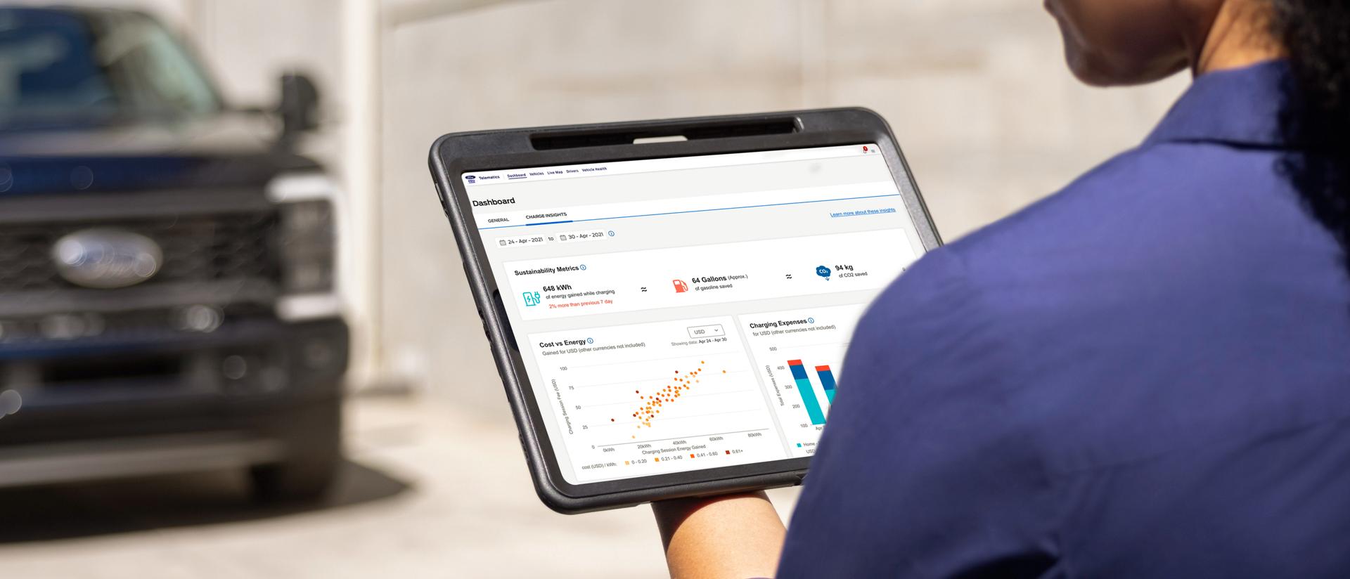 Worker using a tablet while a 2026 Ford Super Duty® Chassis Cab is blurred in the background