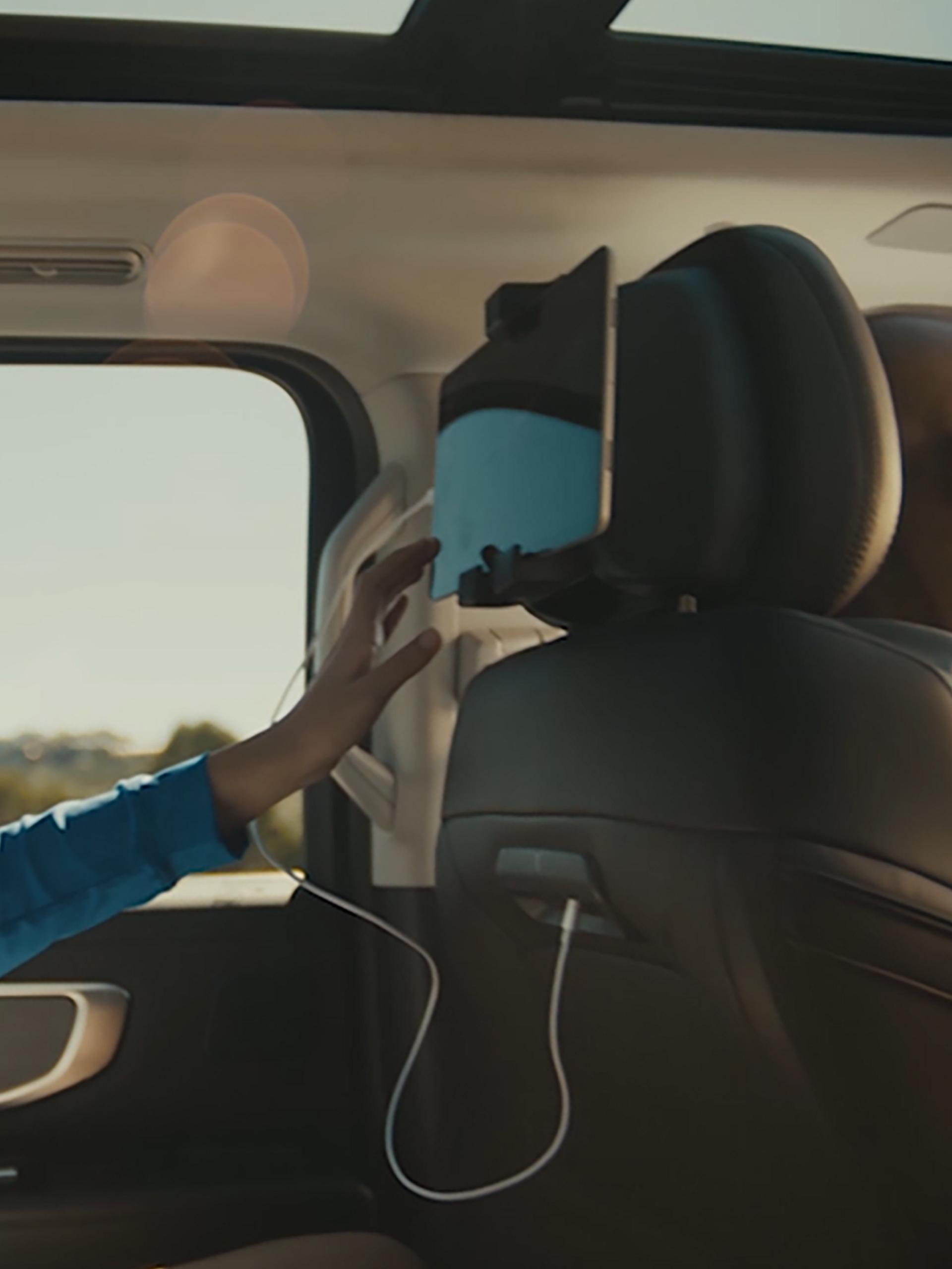 Person using the available digital device holder in the second row of a 2026 Ford Expedition® SUV