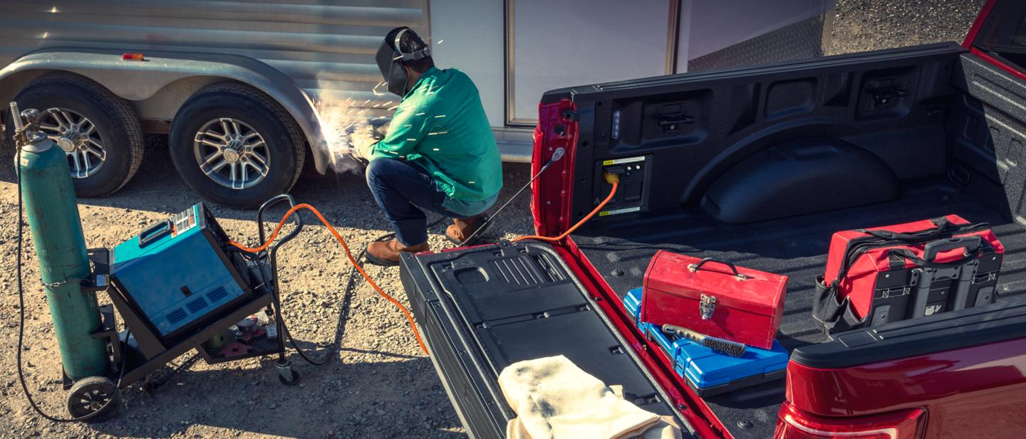 A man uses the Pro Power Onboard feature to power a welding tool plugged into an F-150.