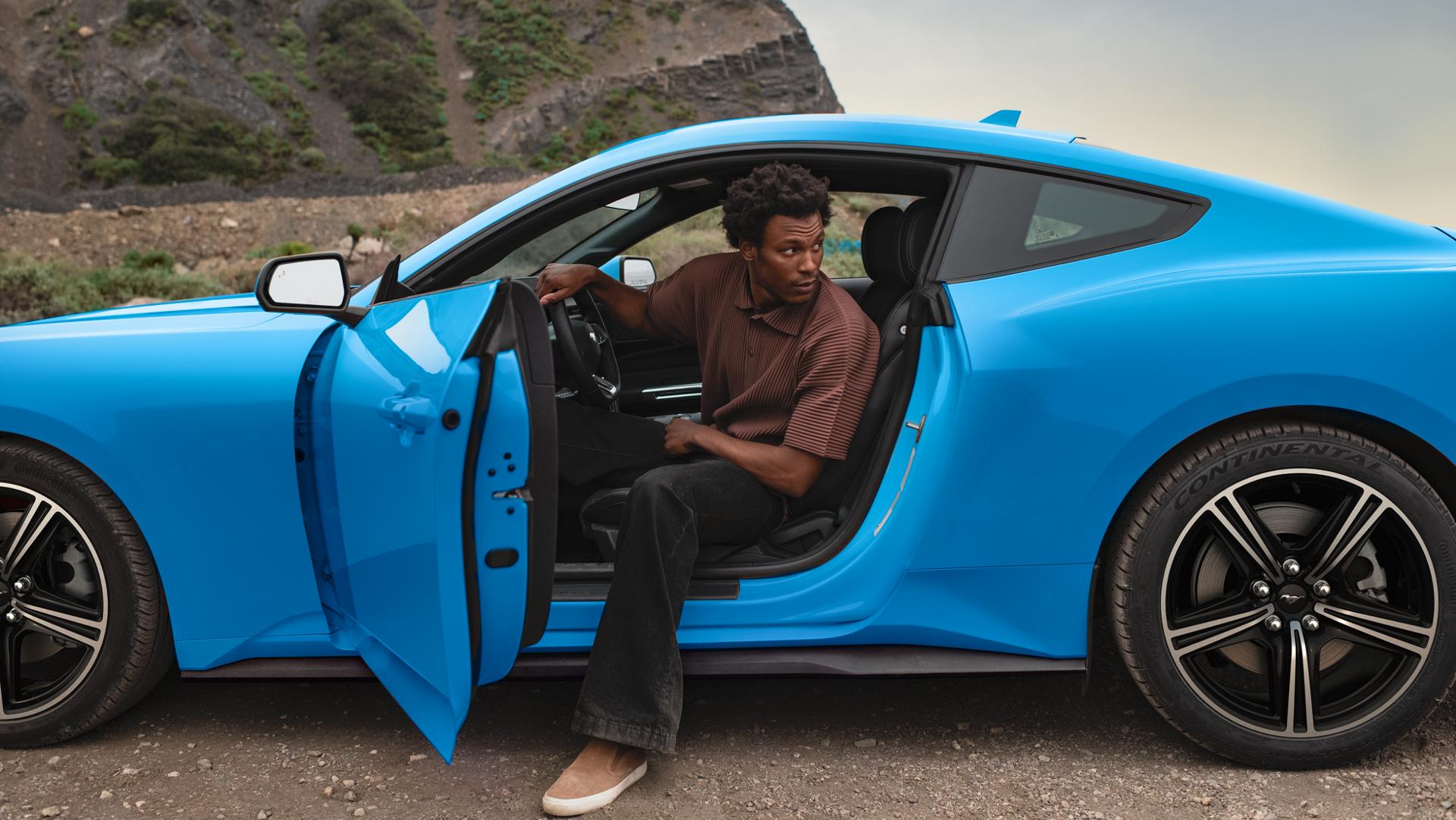Person exiting a 2025 Ford Mustang® coupe parked in the desert