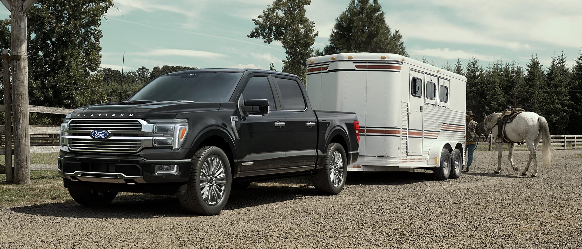2026 Ford F-150® XLT pickup in Agate Black hitched to horse trailer