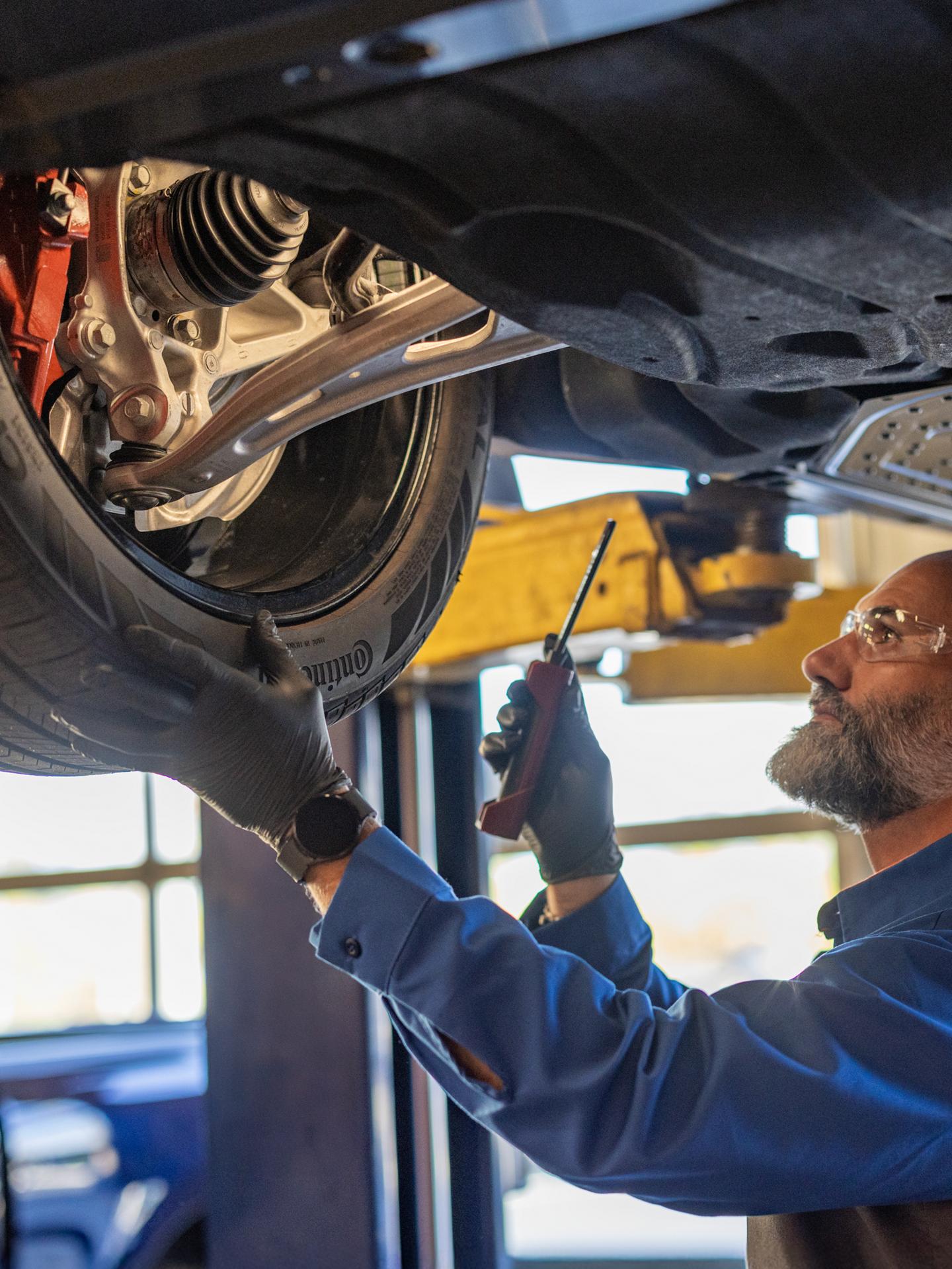 Service technician works on an electric vehicle on a lift.