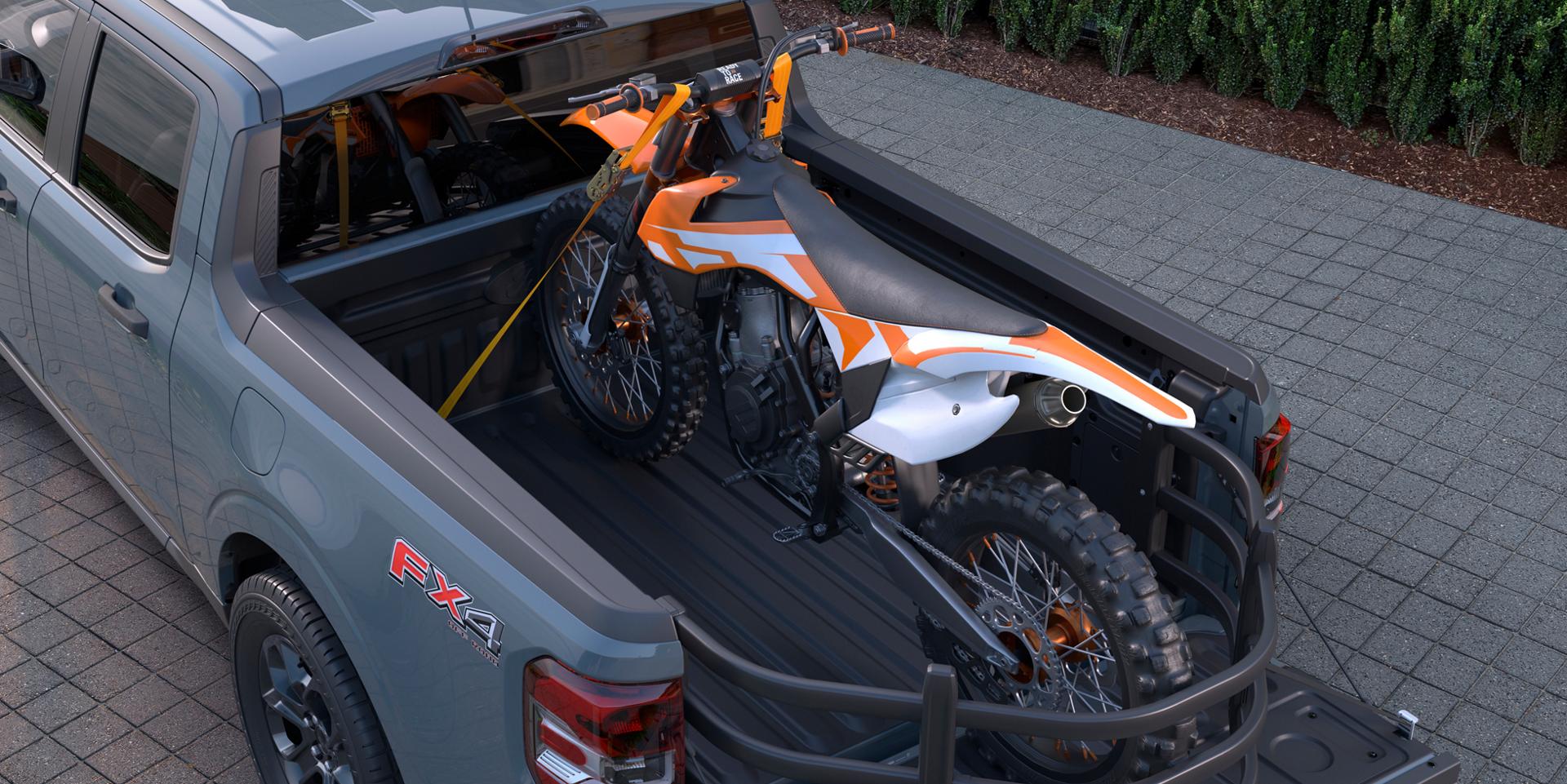 2026 Ford Maverick® FX4 model shown with available Ford Accessories with a dirt bike secured in the bed