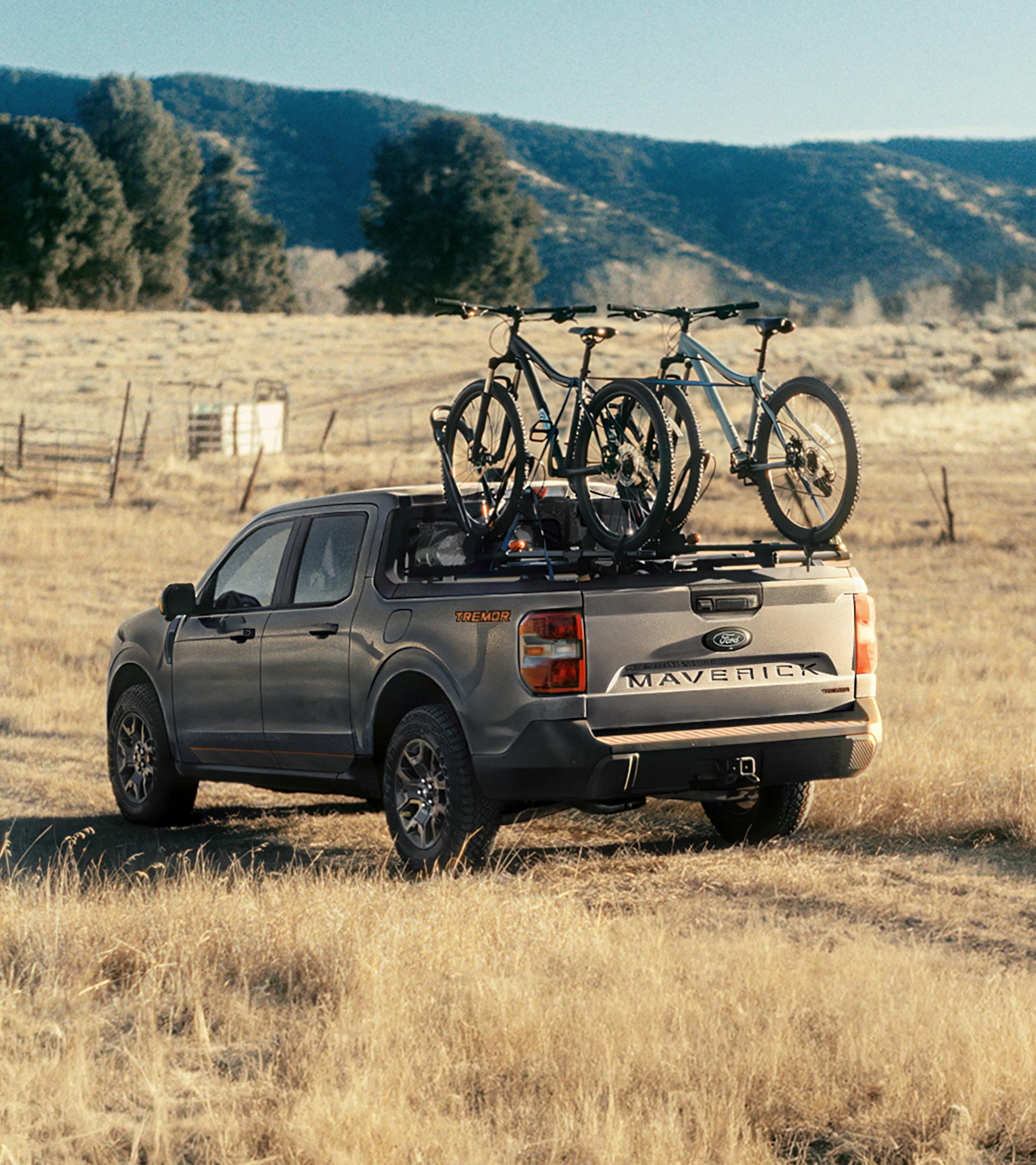 2026 Ford Maverick® Tremor® model being driven on a grassy field with bikes mounted in the bed