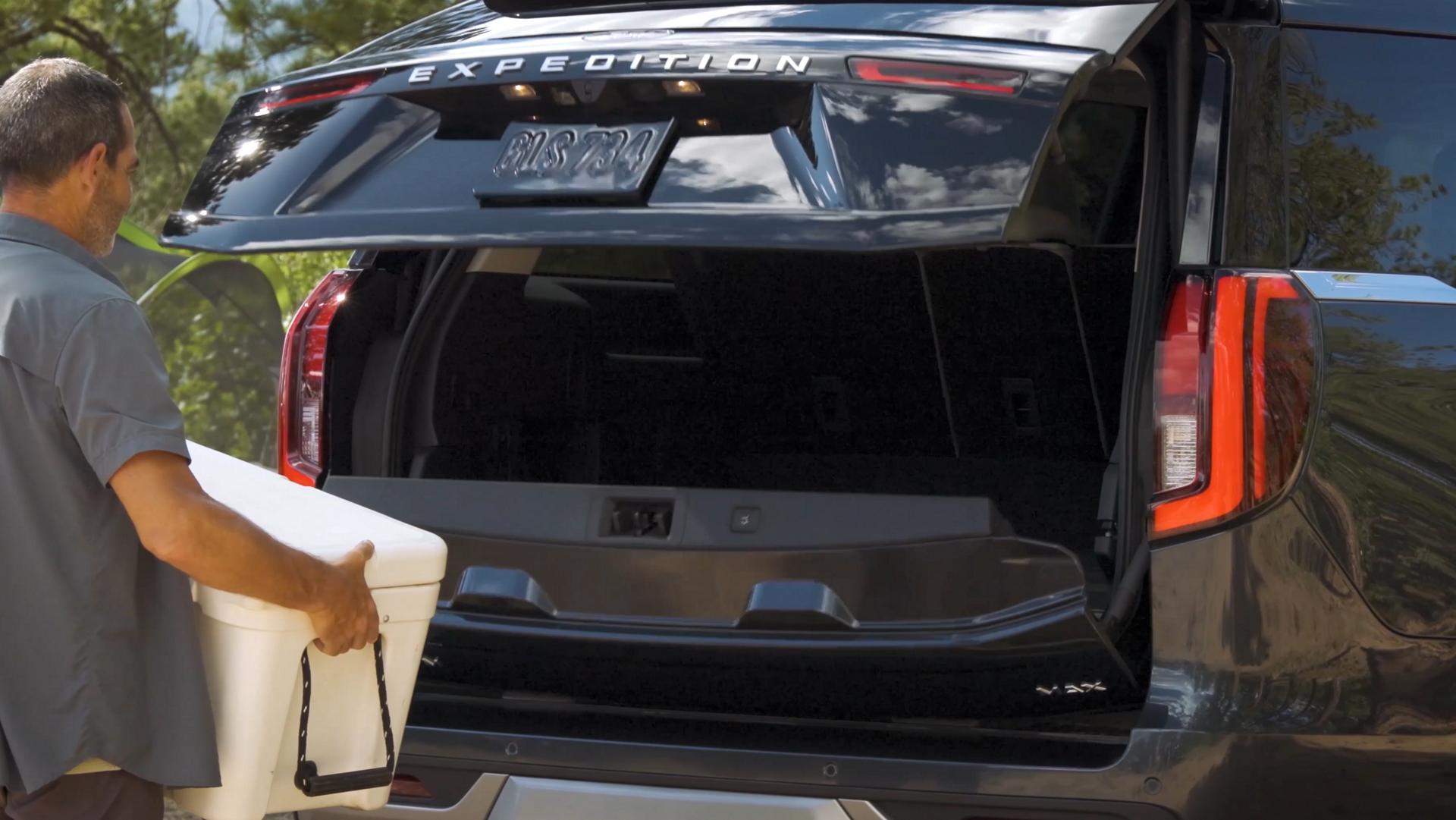 Person using the Ford Split Gate with available Open On Approach to load a cooler in a 2026 Ford Expedition® SUV