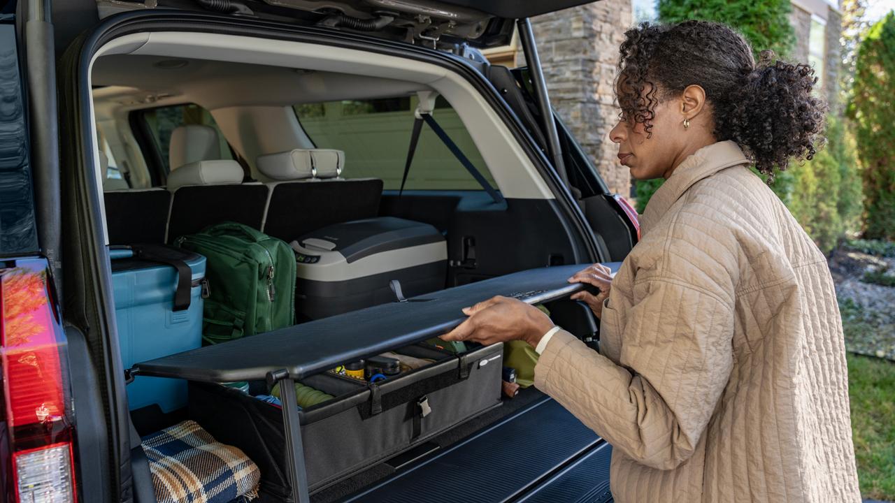Person using the available Cargo Tailgate Manager shelf in a 2027 Ford Expedition® SUV  