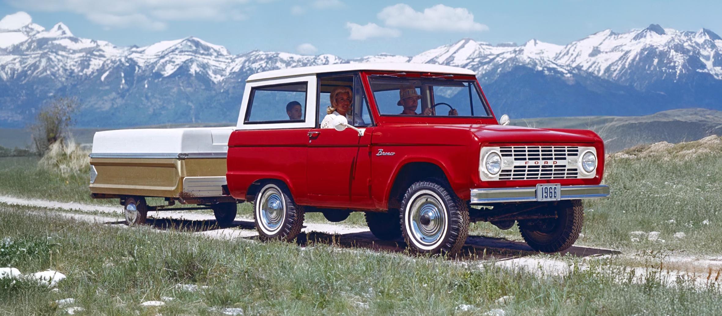 1960s Bronco wagon with a small trailer attached.