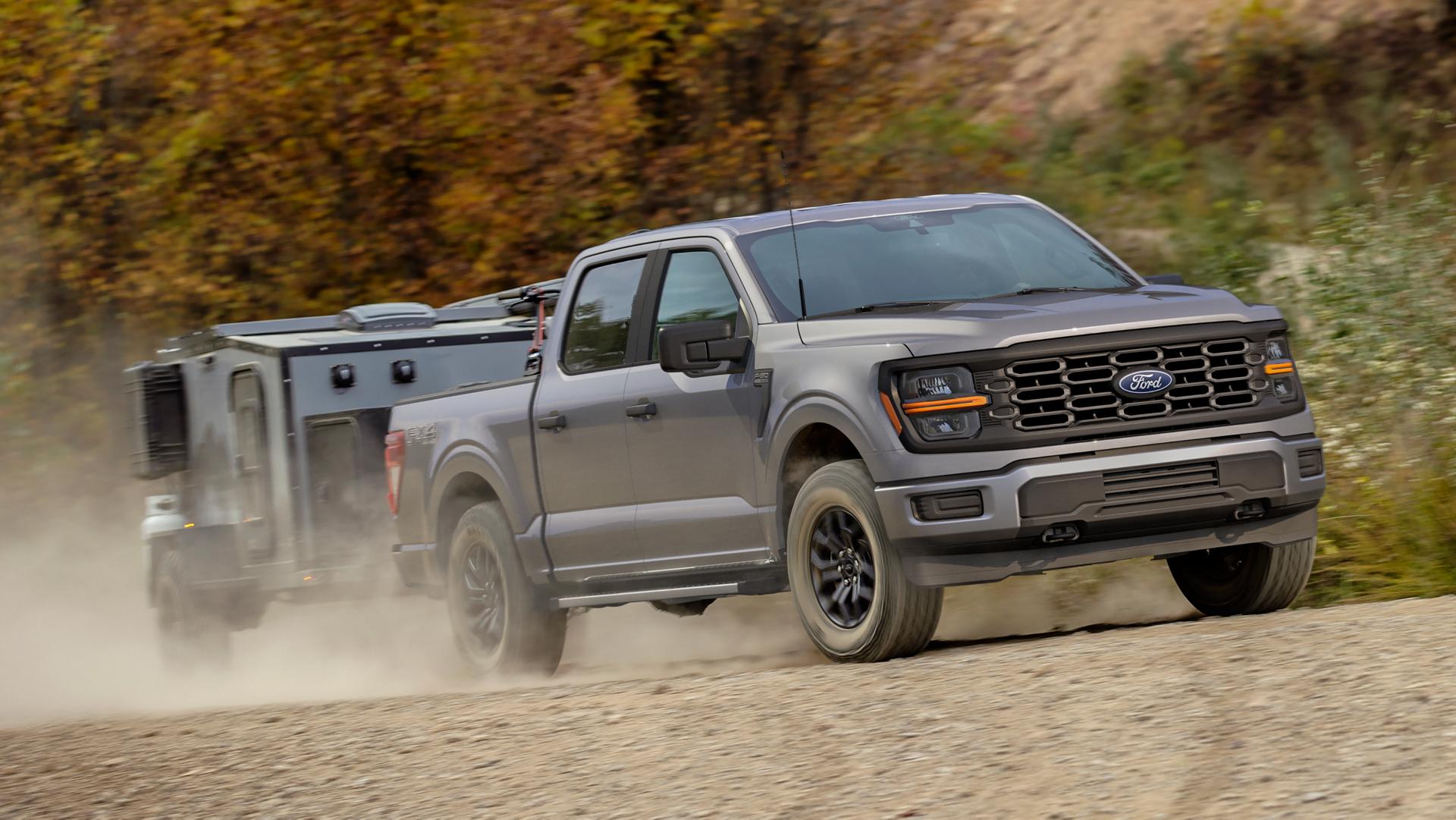 2025 Ford F-150® FX4® model pulling a small camper on a dirt road