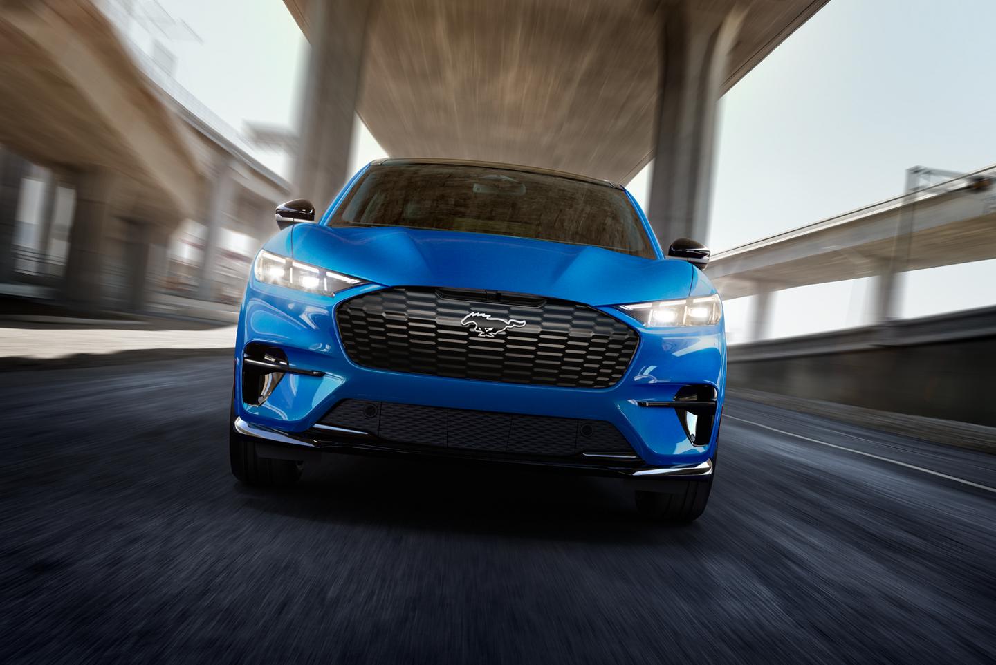 A mustang Mach-E driving on an urban road.