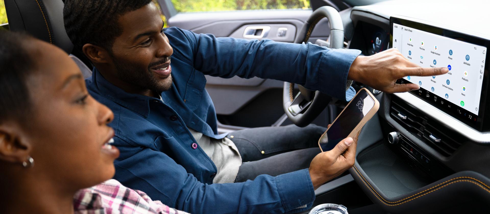 Two people in a 2026 Ford Explorer® SUV with the BlueCruise system active, using the centre display