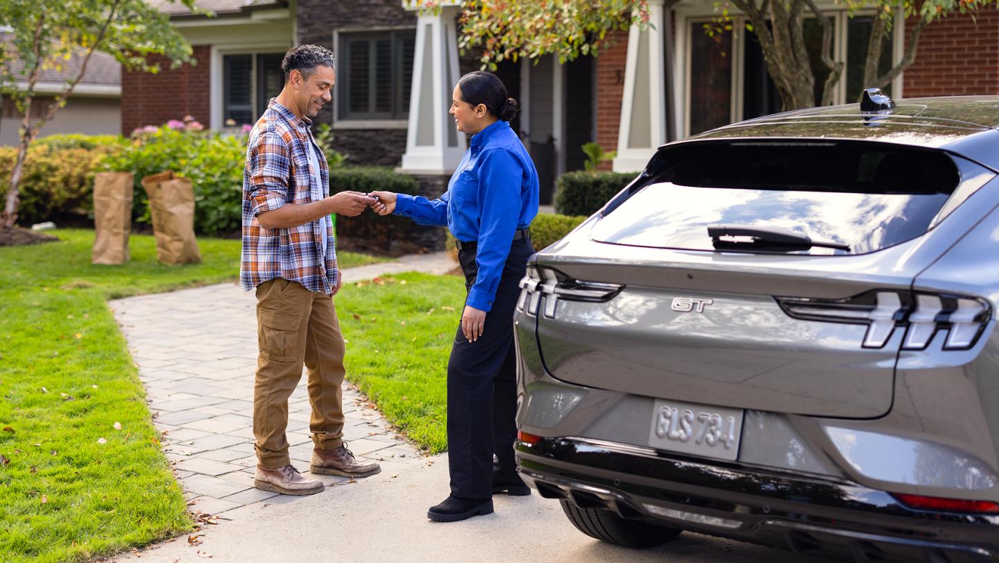 A customer hands the keys to their vehicle to a Ford Service employee.