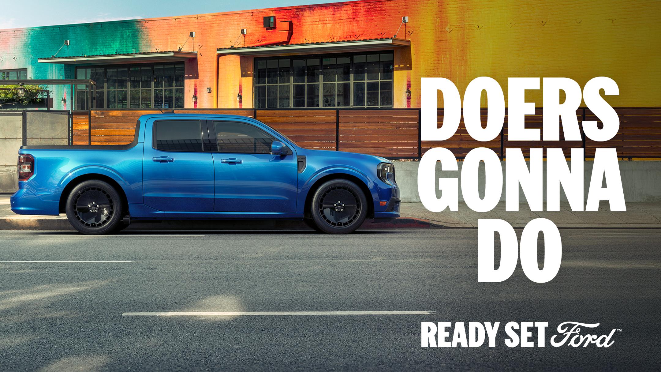Side profile view of a blue Ford Maverick parked outside a colour city building.