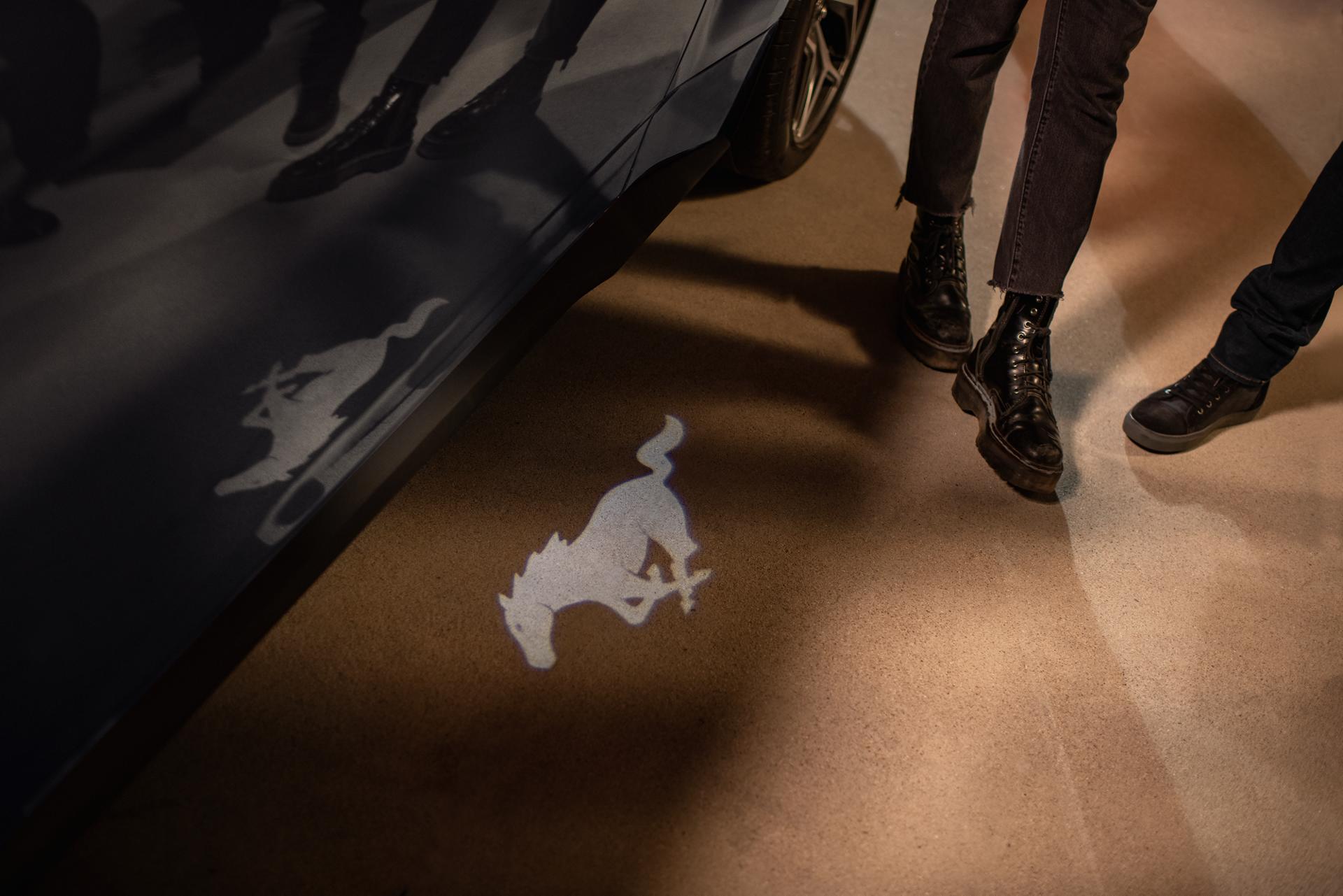 People approaching a 2026 Ford Mustang® GT Premium model with approach detection welcome exterior lighting