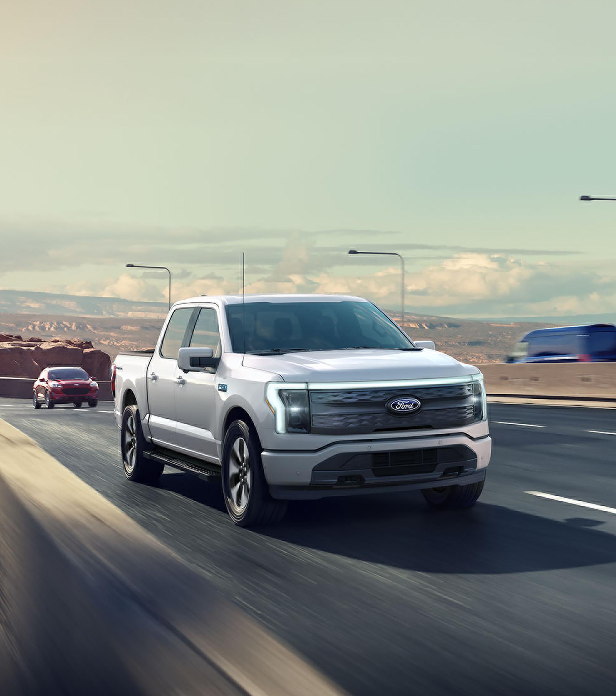 A 2025 Ford F-150® Lightning® pickup driving on an expressway