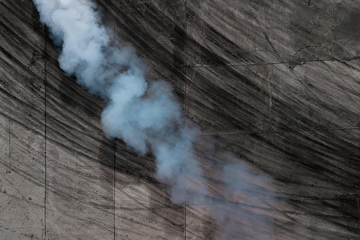 Aerial shot of tire skid marks and smoke on pavement.