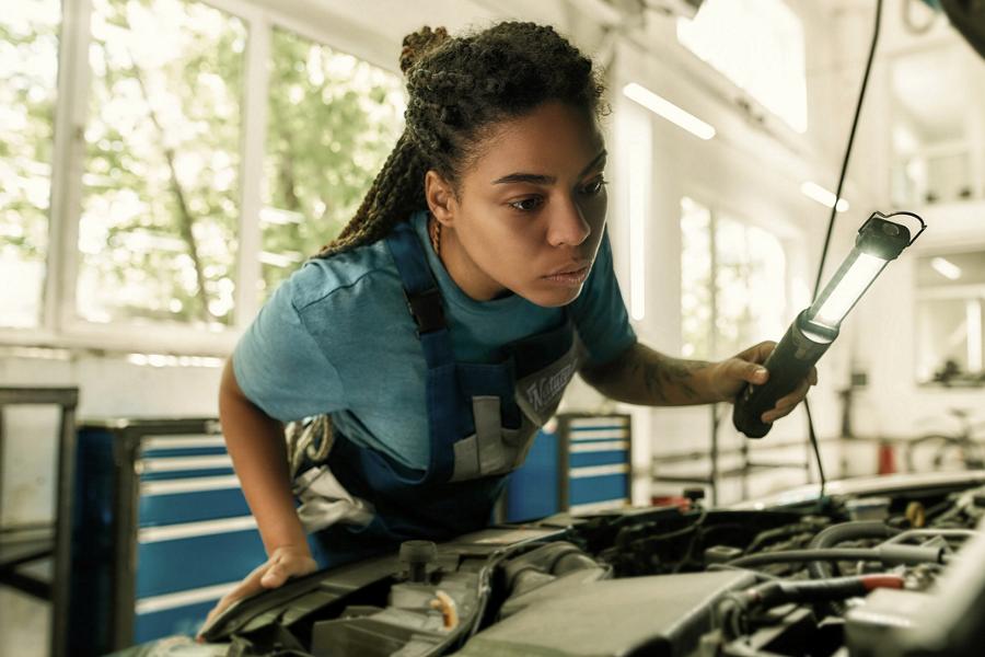 Ford trainee inspects the engine of a vehicle.