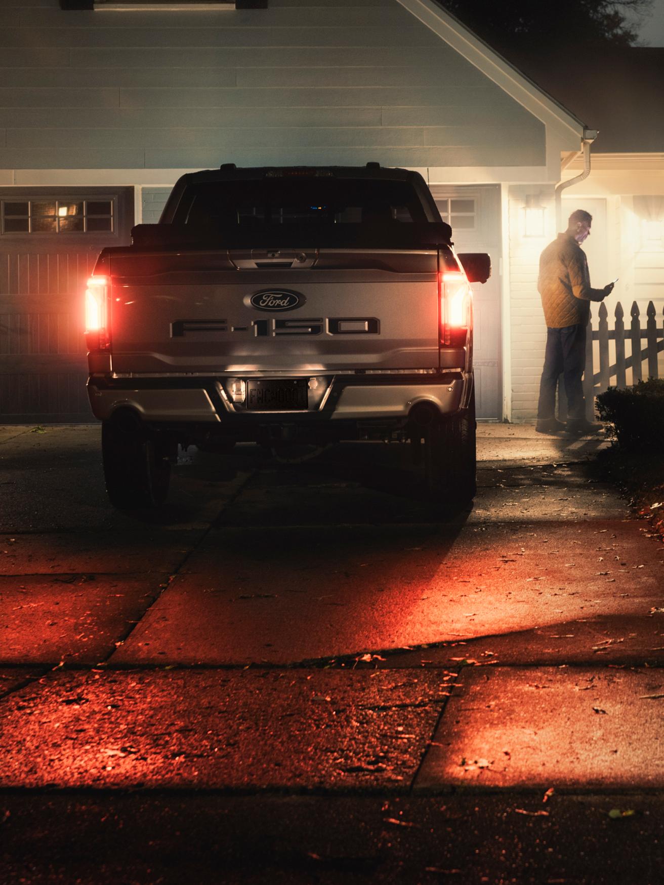 An F-150 Lightning parked in front of a house at night.