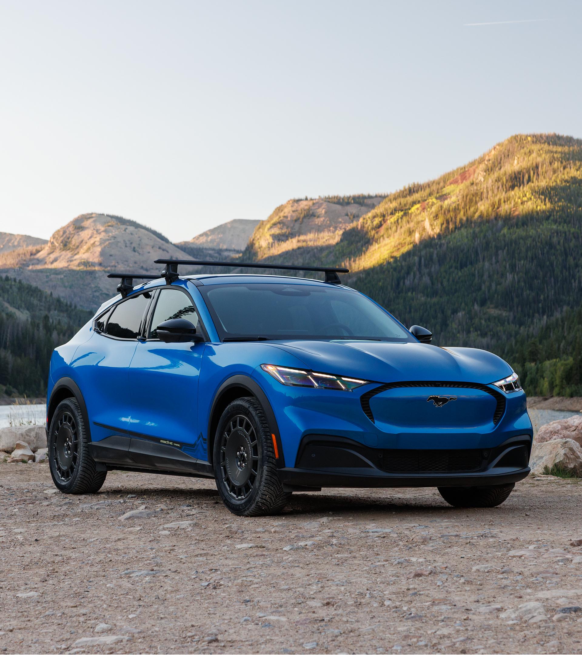 2027 Mustang Mach-E® SUV with optional Trail package and available Ford bike rack accessory parked off road