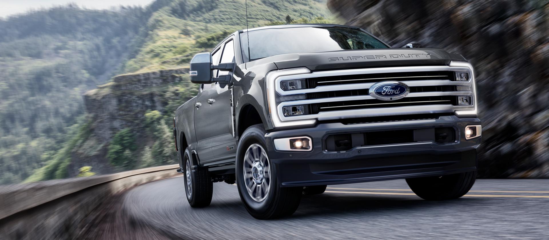 2026 Ford Super Duty® F-350® with the Platinum® Plus Package driving on a paved road in the mountains