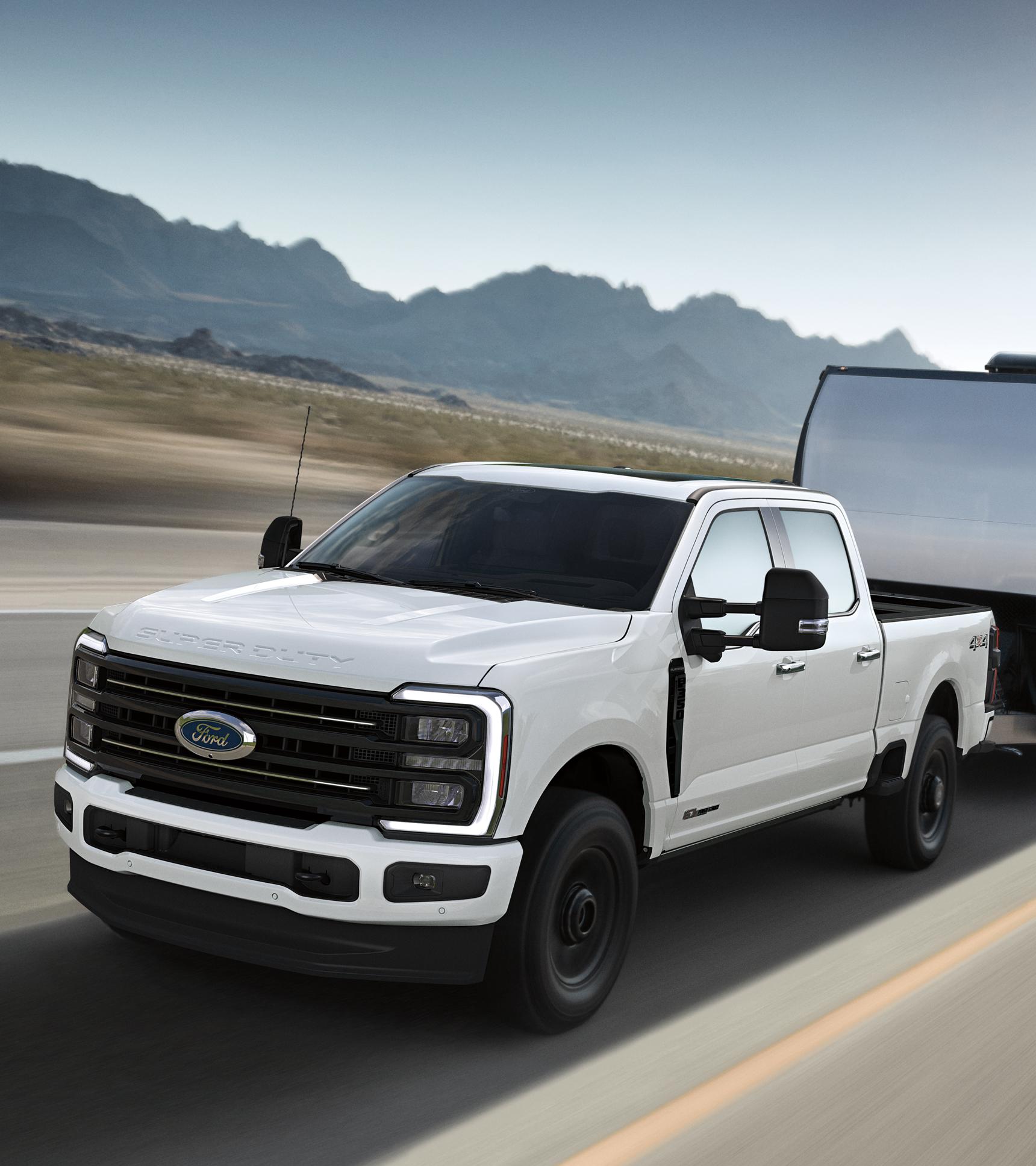 A 2026 Ford Super Duty® F-350® Platinum® model in Star White with the STX Appearance Package pulling a large trailer