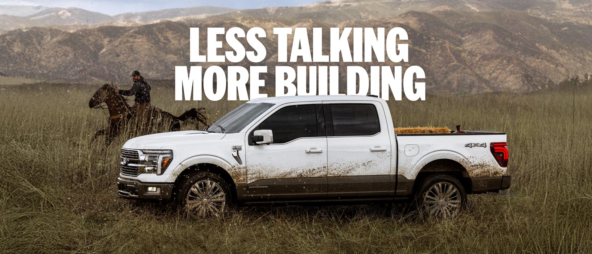A side profile of a white Ford F-150 driving in a field beside a rider on horseback with a mountain range in the background. "Less talking more building."