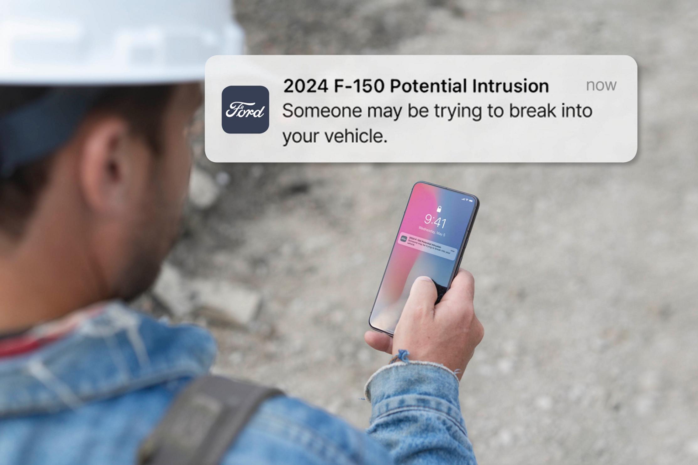 Person holding a smartphone displaying a notification. Overlay of text that reads: Potential intrusion! Someone may be trying to break into your vehicle.