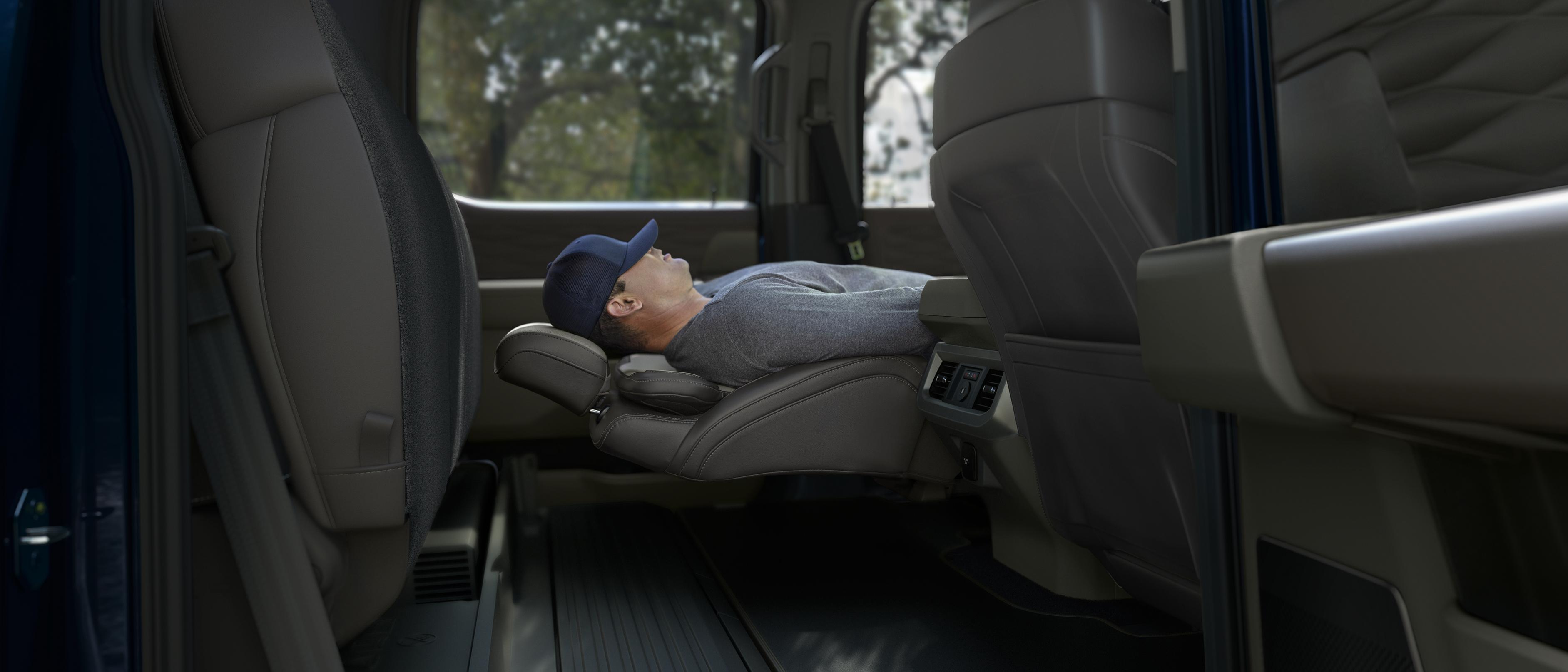 Person sleeping while using the Max Recline front seats feature in their 2026 Ford Super Duty® truck