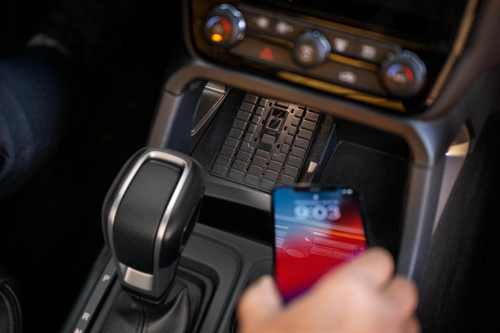 Close-up of a person placing a phone on the wireless charger in the 2025 Ford Ranger®