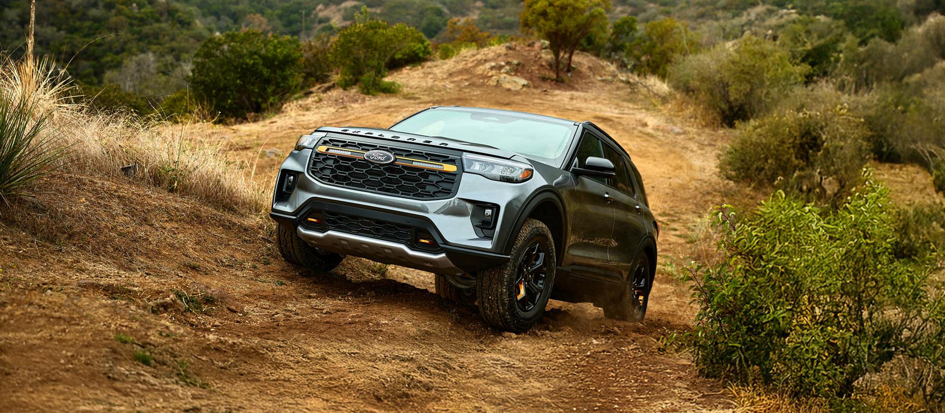 A close-up of the front of a 2026 Ford Explorer® Tremor® SUV parked on a dirt road