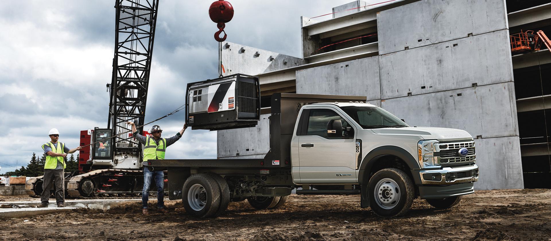 A 2026 Ford Super Duty® Chassis Cab parked on a construction site while something is being loaded onto the flatbed