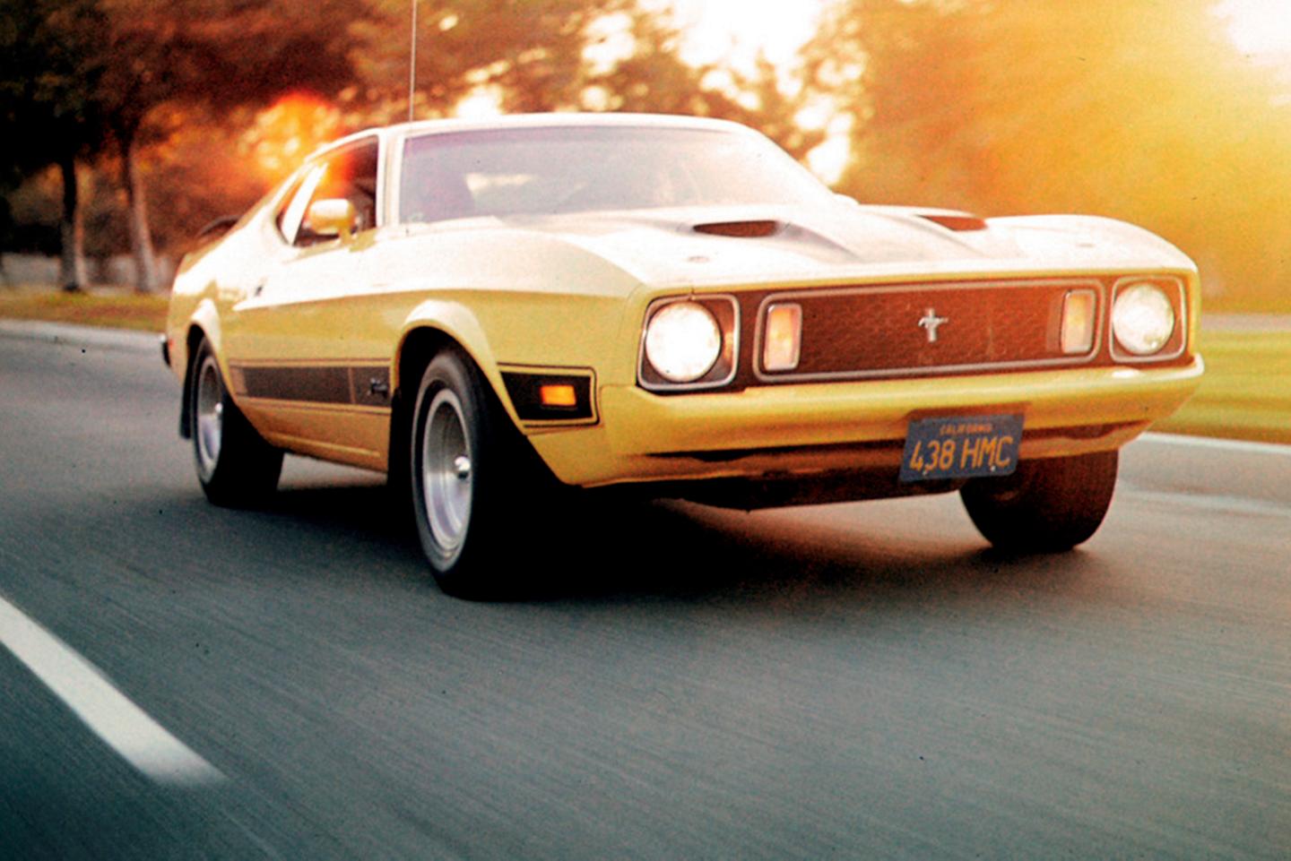 Vintage Mustang driving on a suburban road.