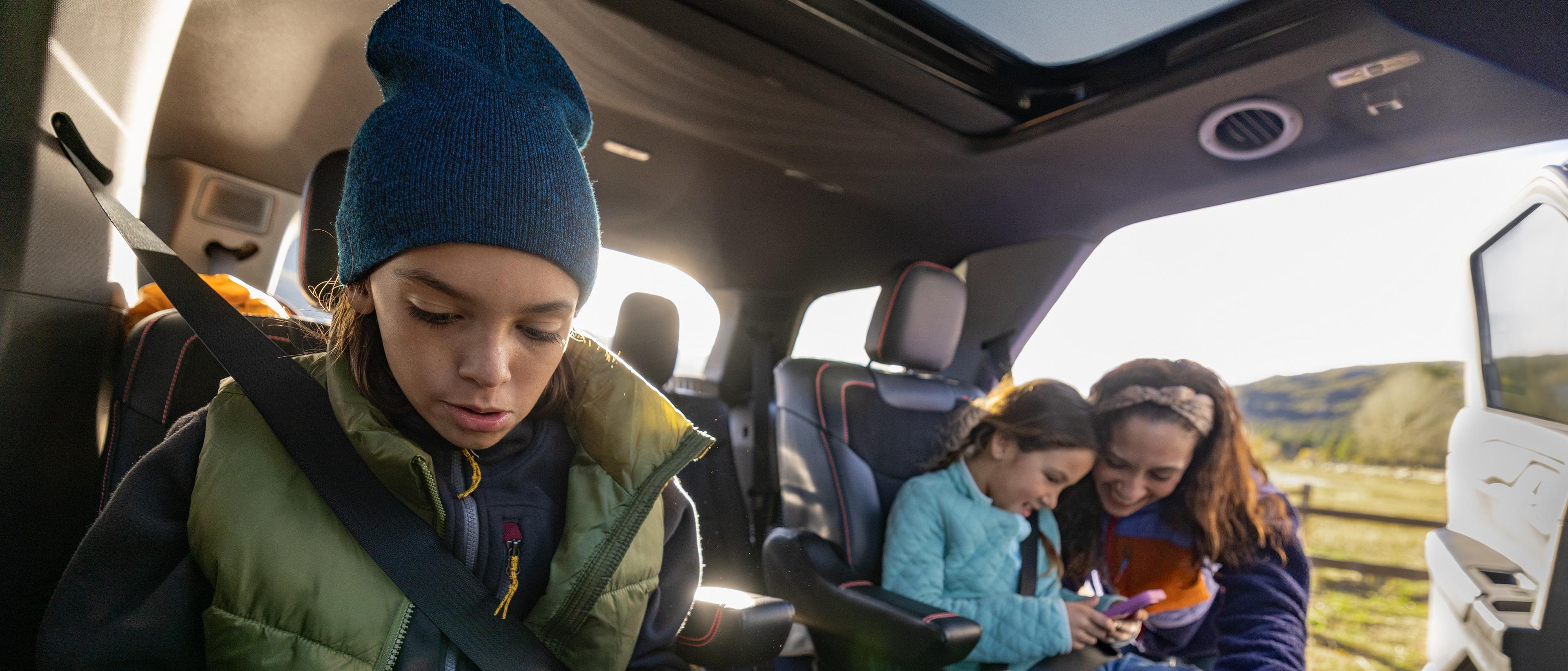 A family using their devices while seated in a parked 2026 Ford Explorer® SUV