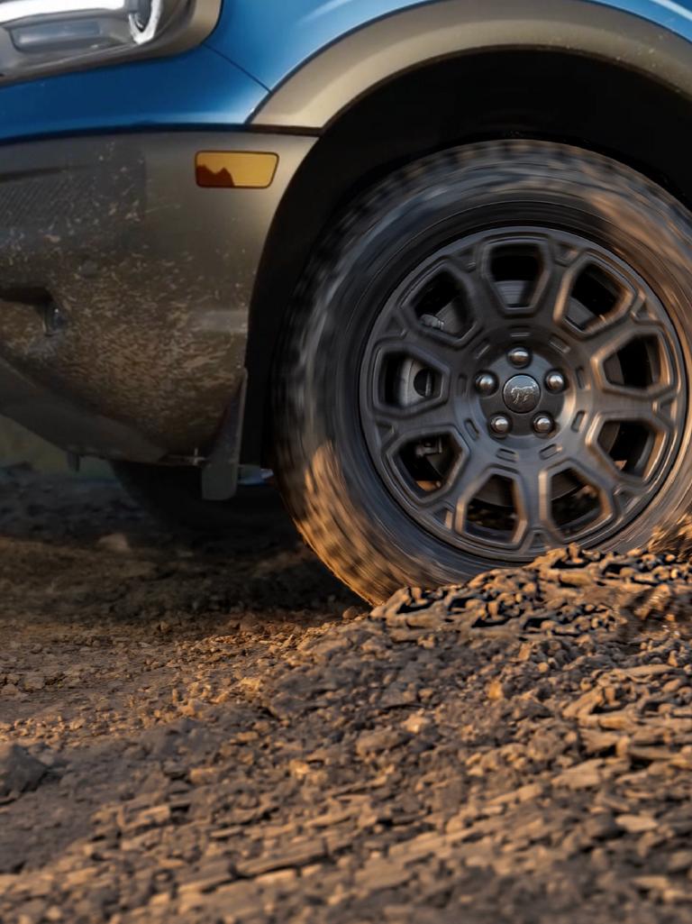 Side profile close-up of a Bronco Sport® rugged tire and front quarter-panel.