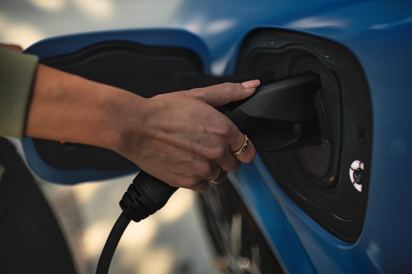 Person plugging in a Ford EV.