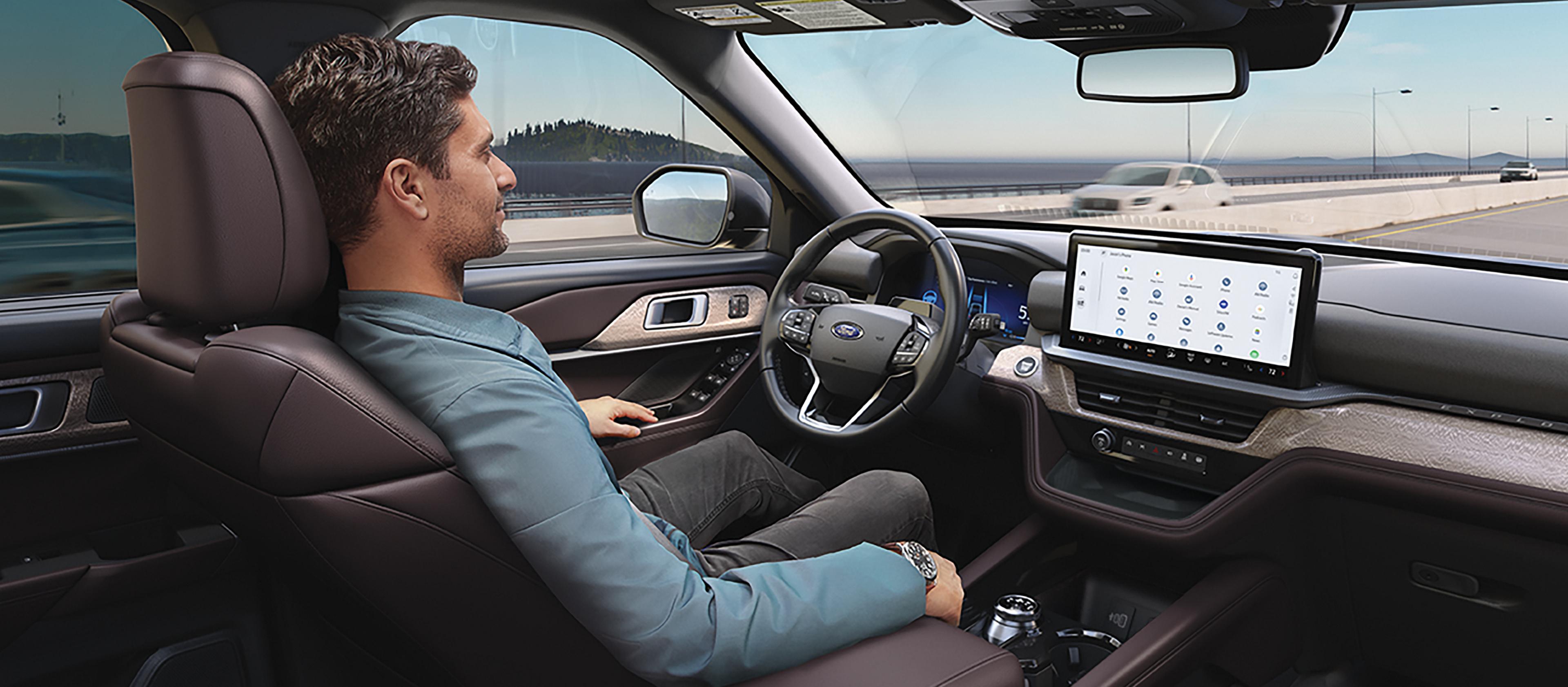 A person in a 2026 Ford Explorer® SUV driving down the highway, using the BlueCruise feature