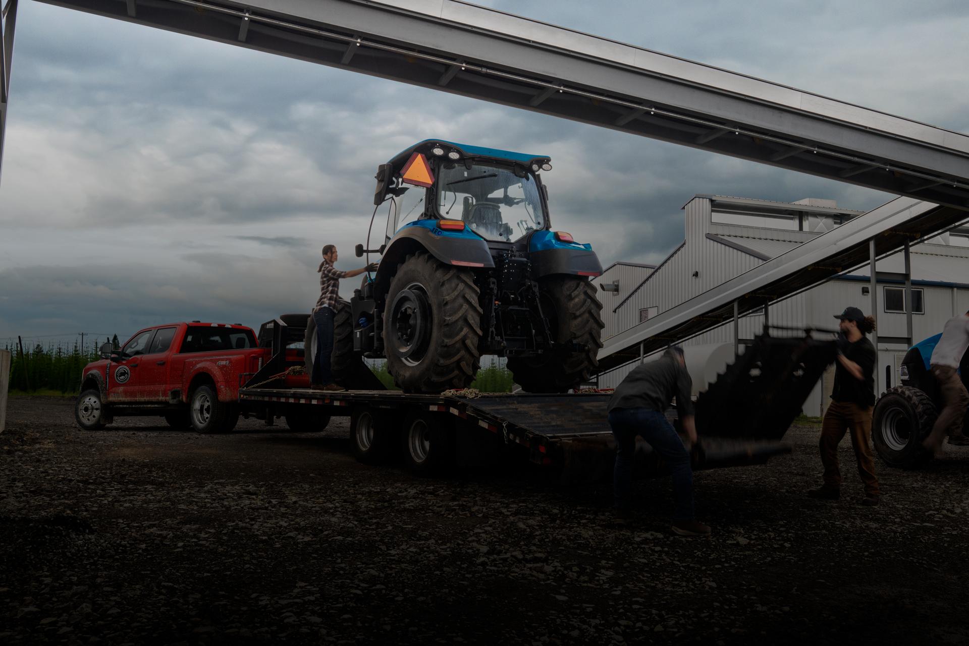 2026 Ford Super Duty® F-450® XL in Race Red pulling a trailer carrying a large tractor