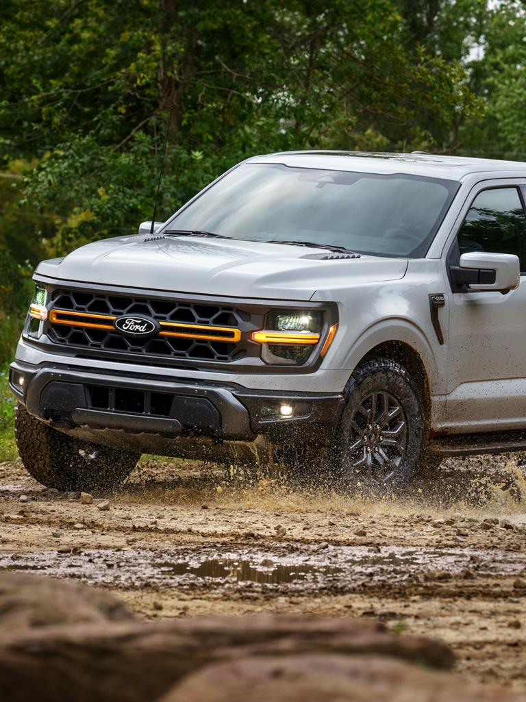 2026 Ford F-150® Tremor® pickup being driven through a muddy puddle