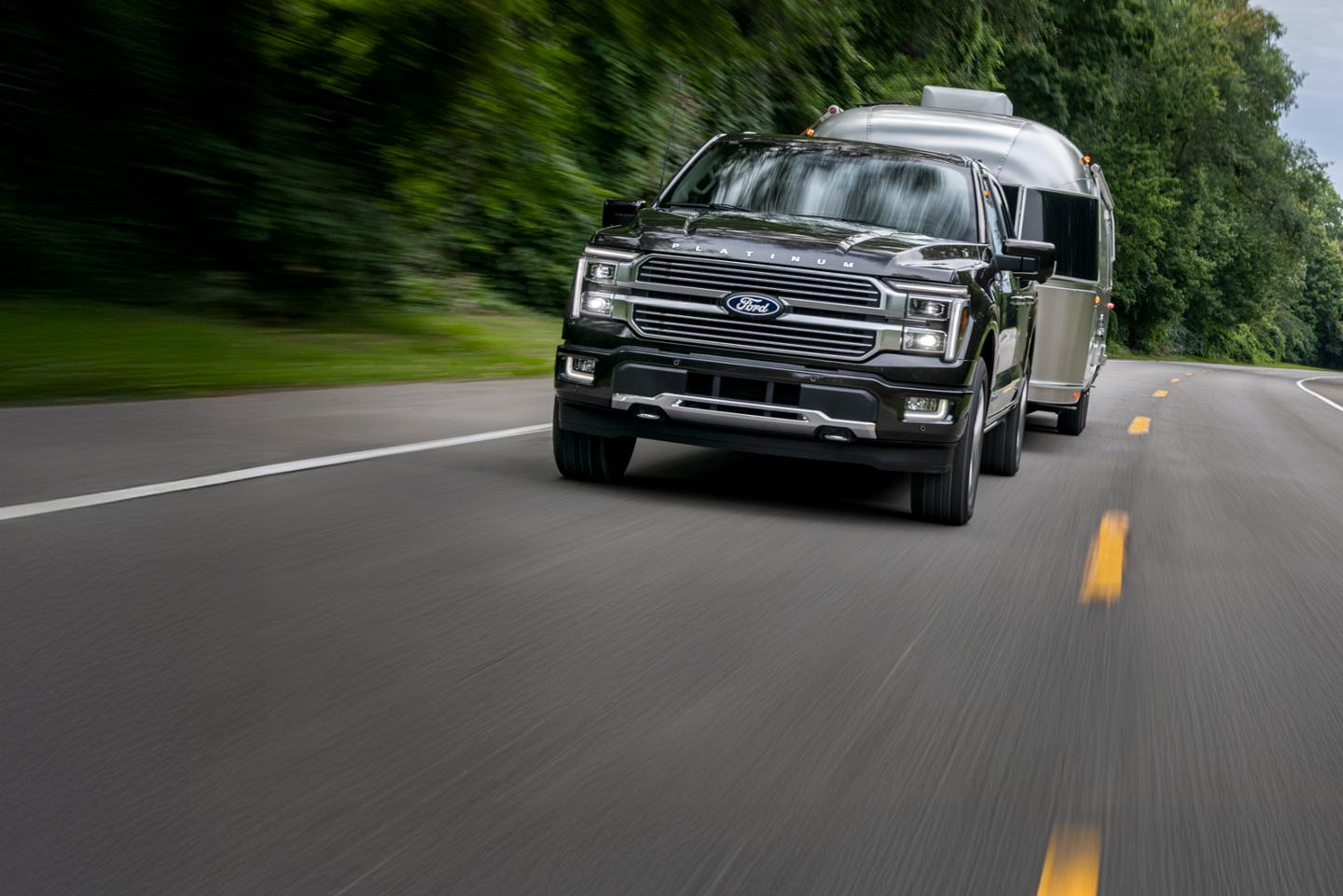 F-150 towing a trailer on a two-lane highway.