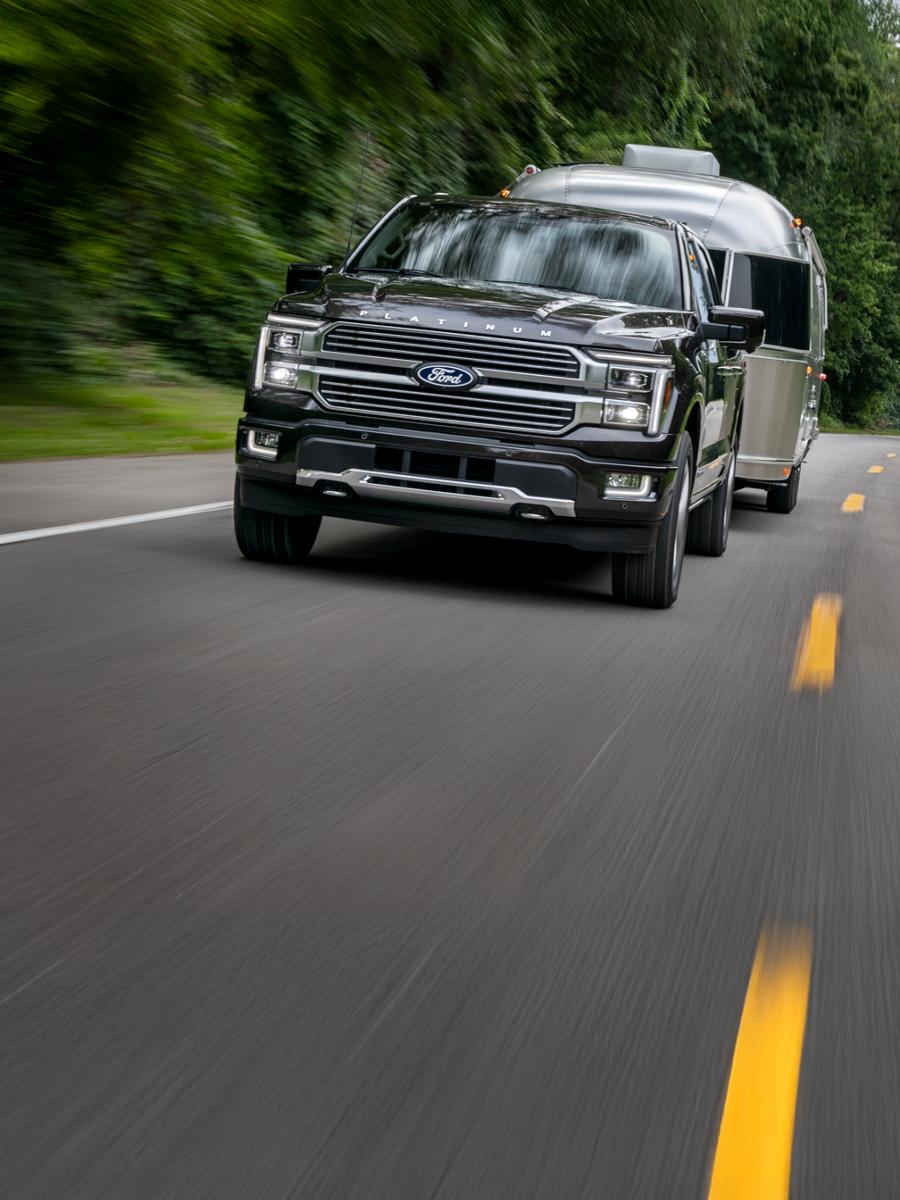 F-150 towing a trailer on a two-lane highway.